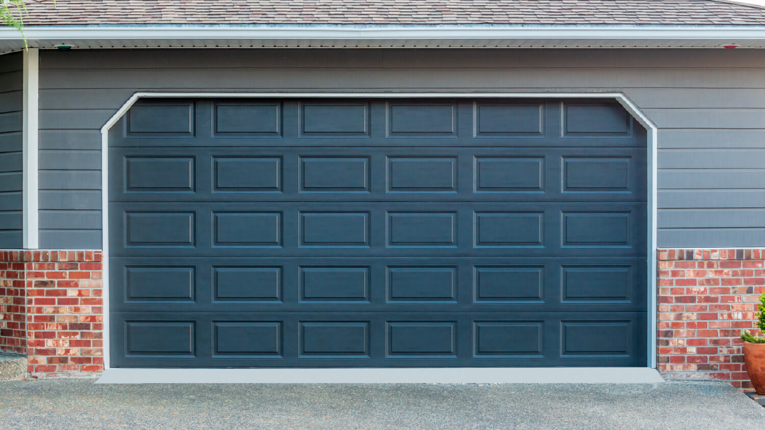 dark blue garage door with blue siding on house