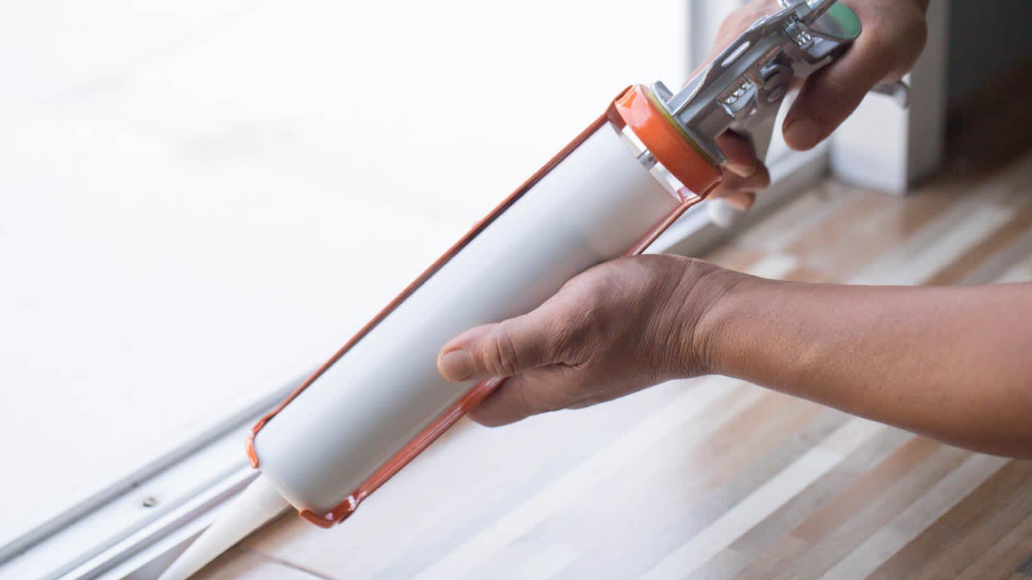 A man using silicone adhesive with a glue gun