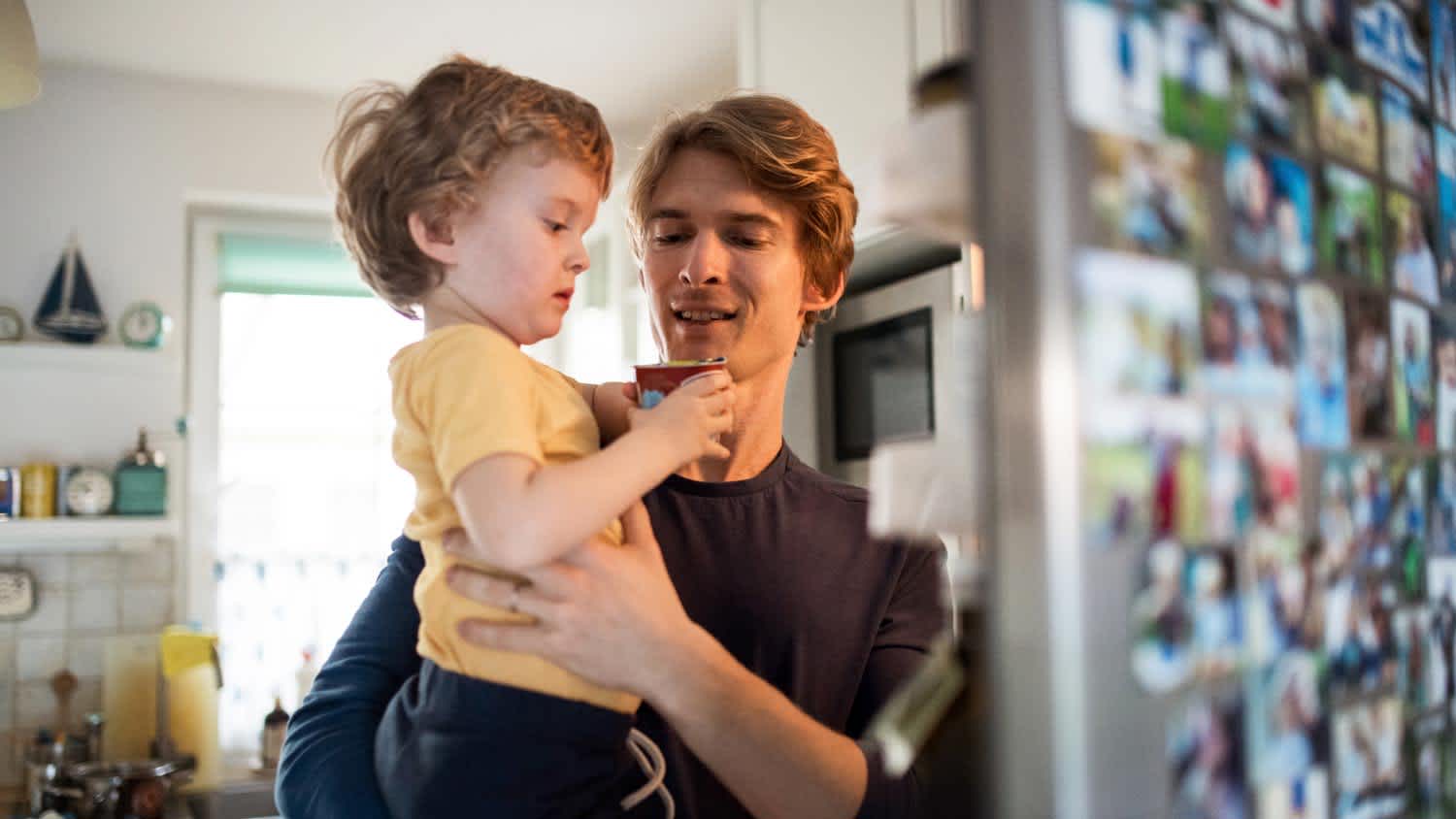 A father with his toddler in front of the fridge