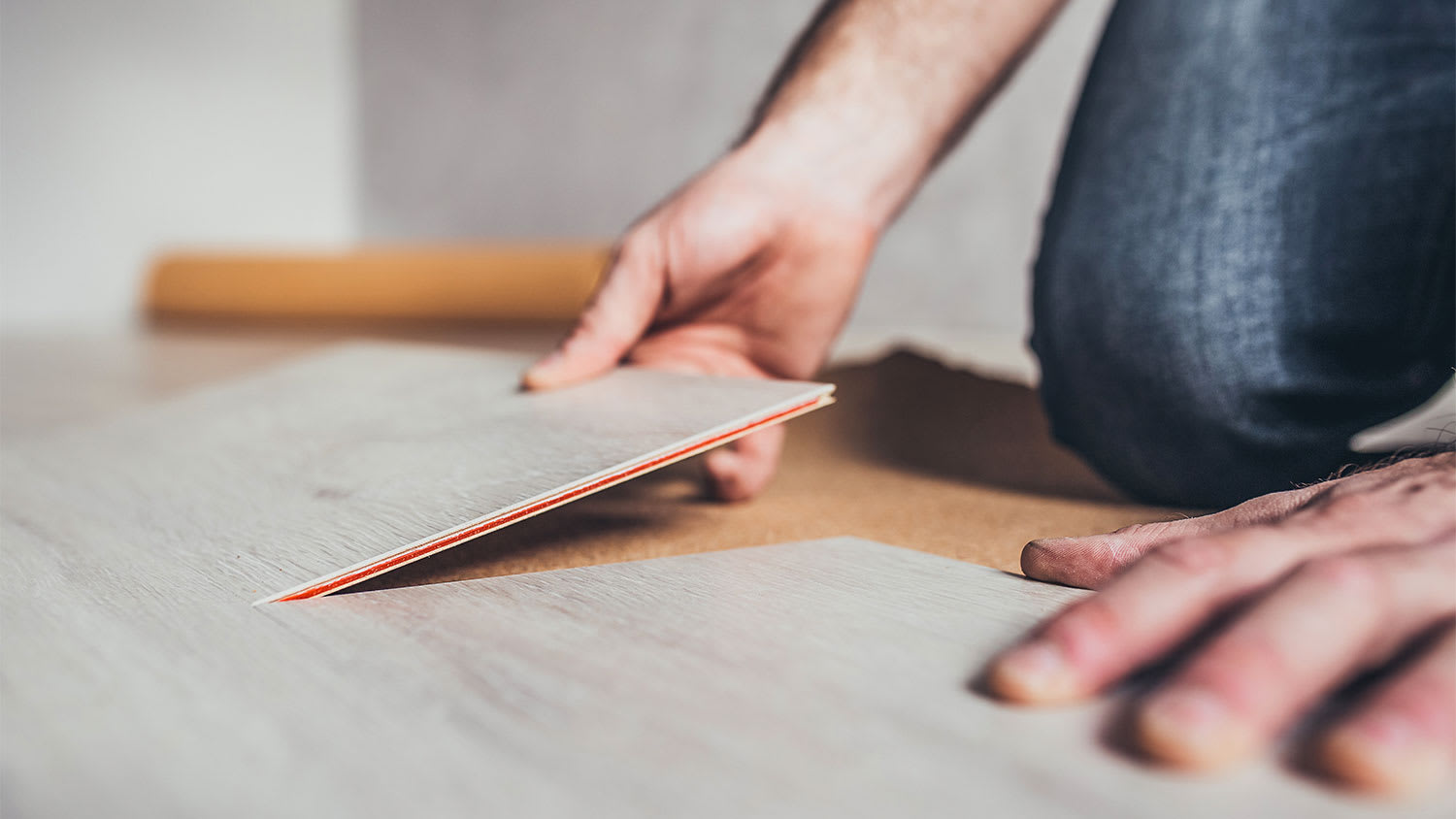 A man installs laminate flooring