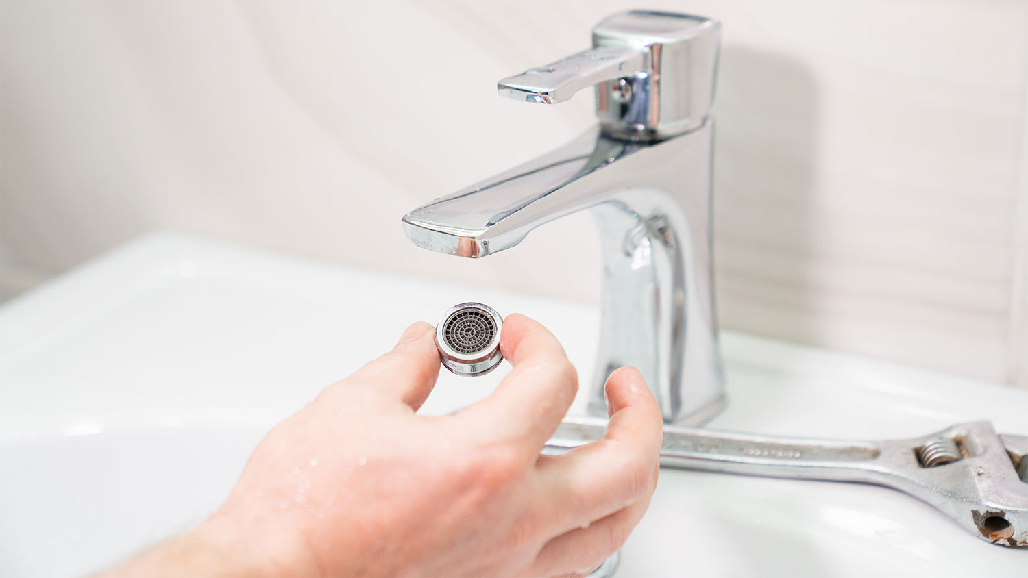 repairman removing aerator from faucet