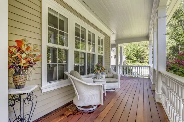 a deck features patio furniture, wood floor, and four large windows