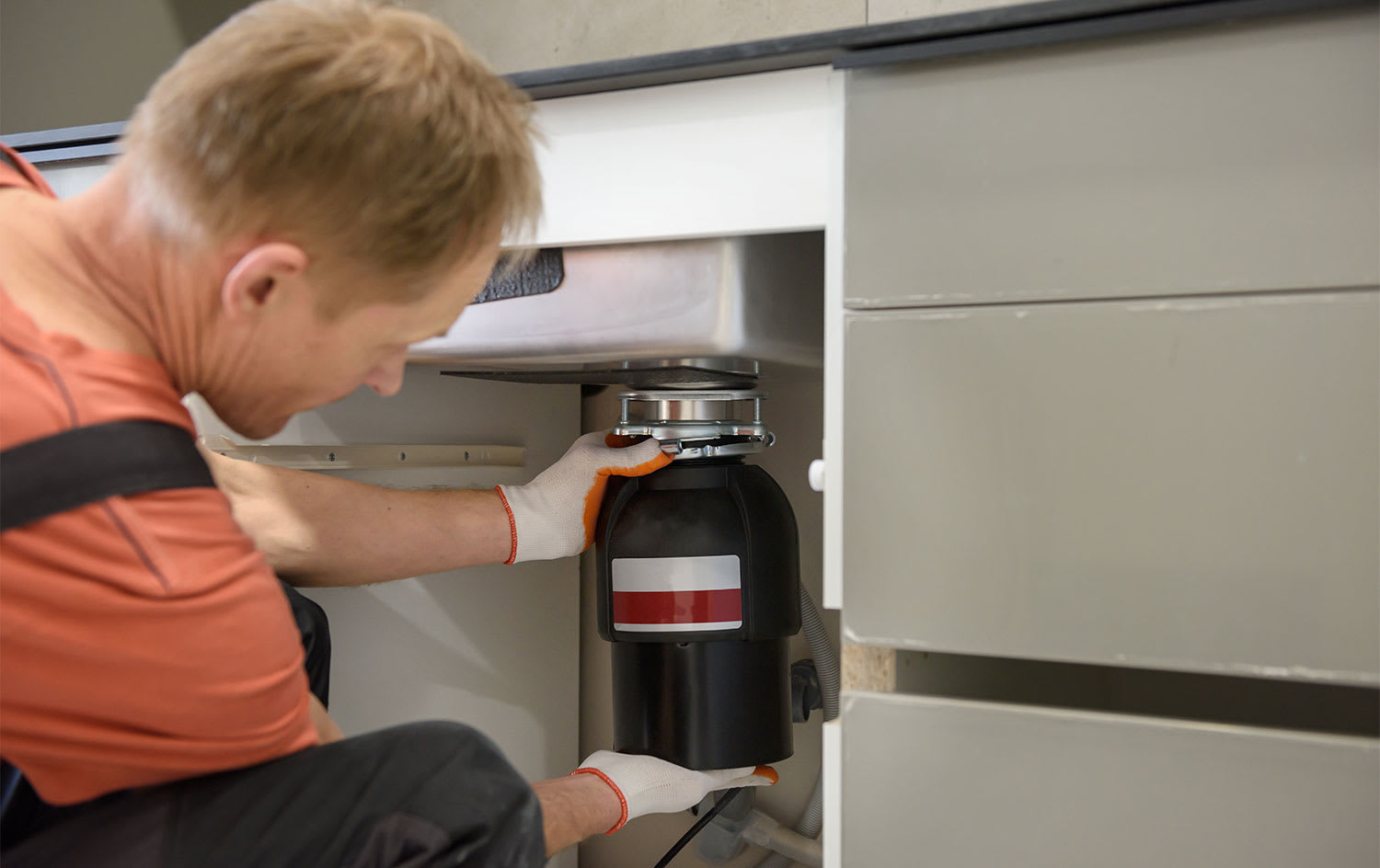 Plumber inspecting kitchen garbage disposal