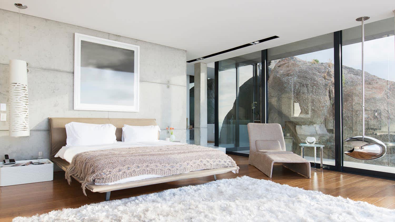 A modern bedroom with amazing views and a white shag rug