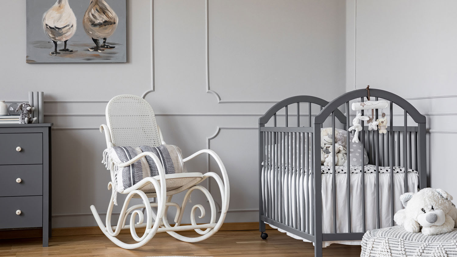 Nursery room with gray walls and white rocking chair