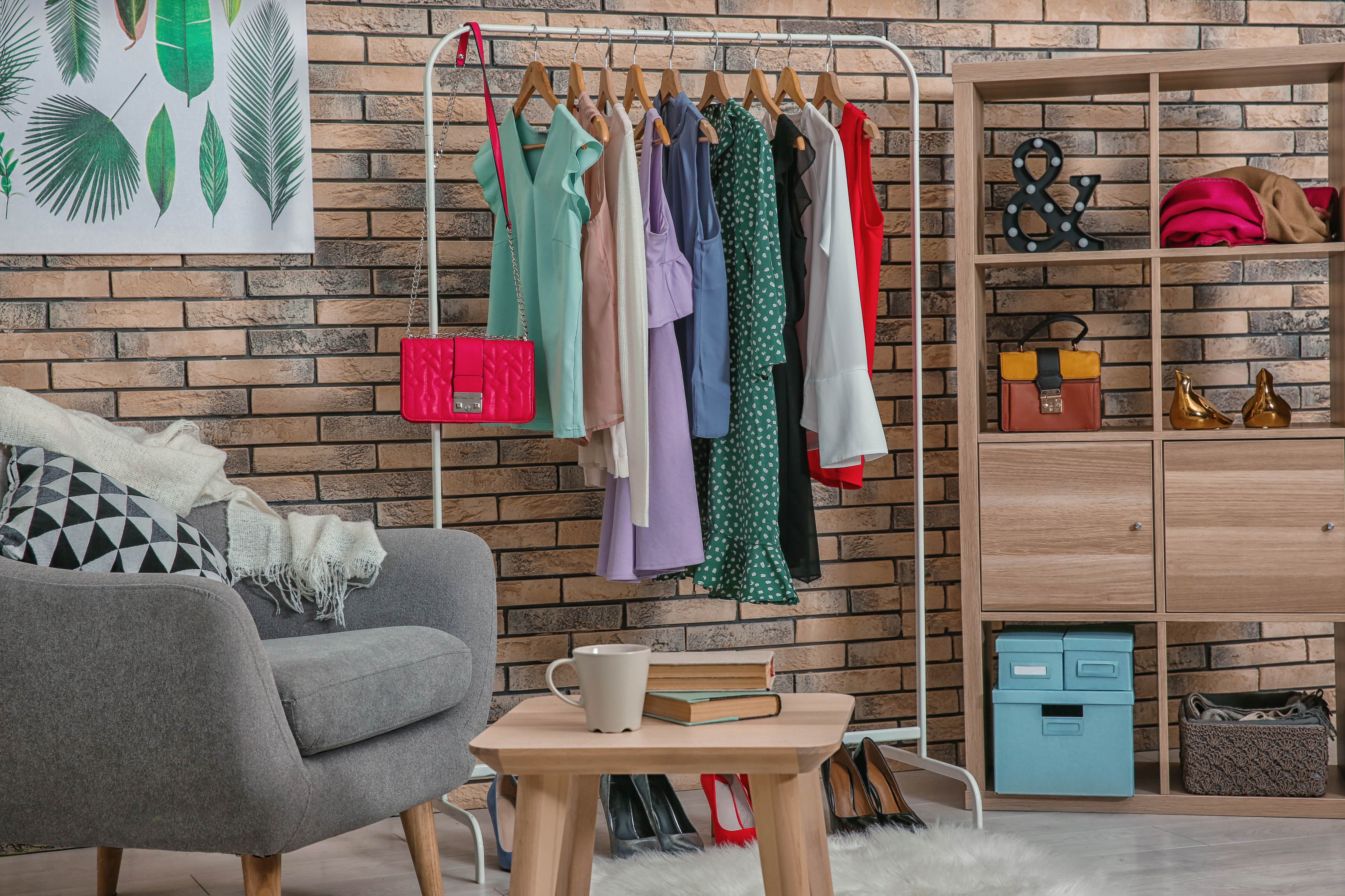 A room corner with a dressing rack, bookshelf, and a comfortable chair