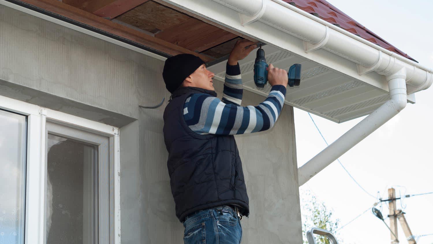 A man installing new fascia