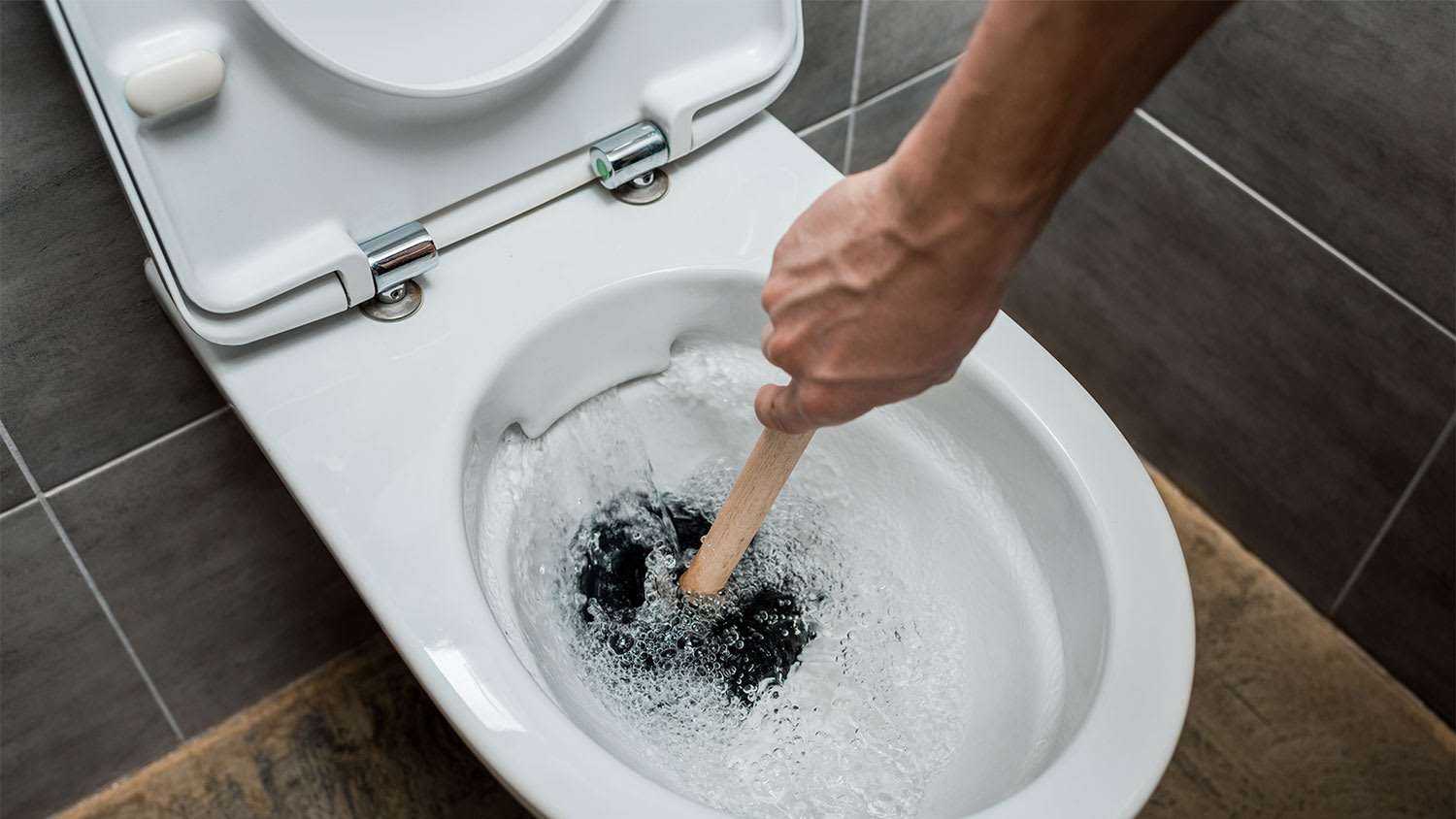 A view of someone plunging a toilet