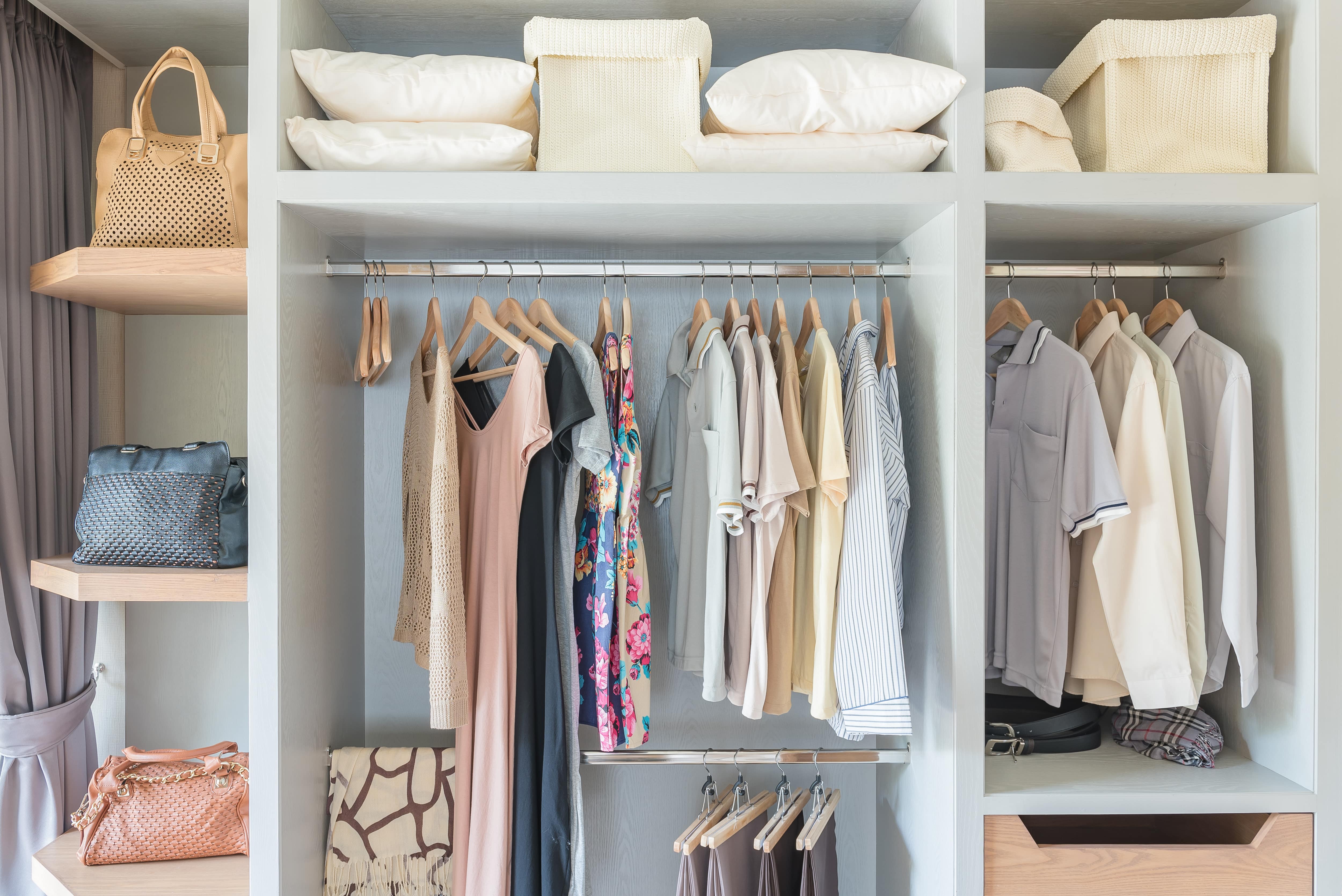 A small closet with tiered hanging racks and shelf storage