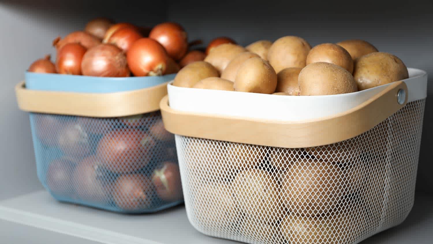 Two baskets storing potatoes and onions