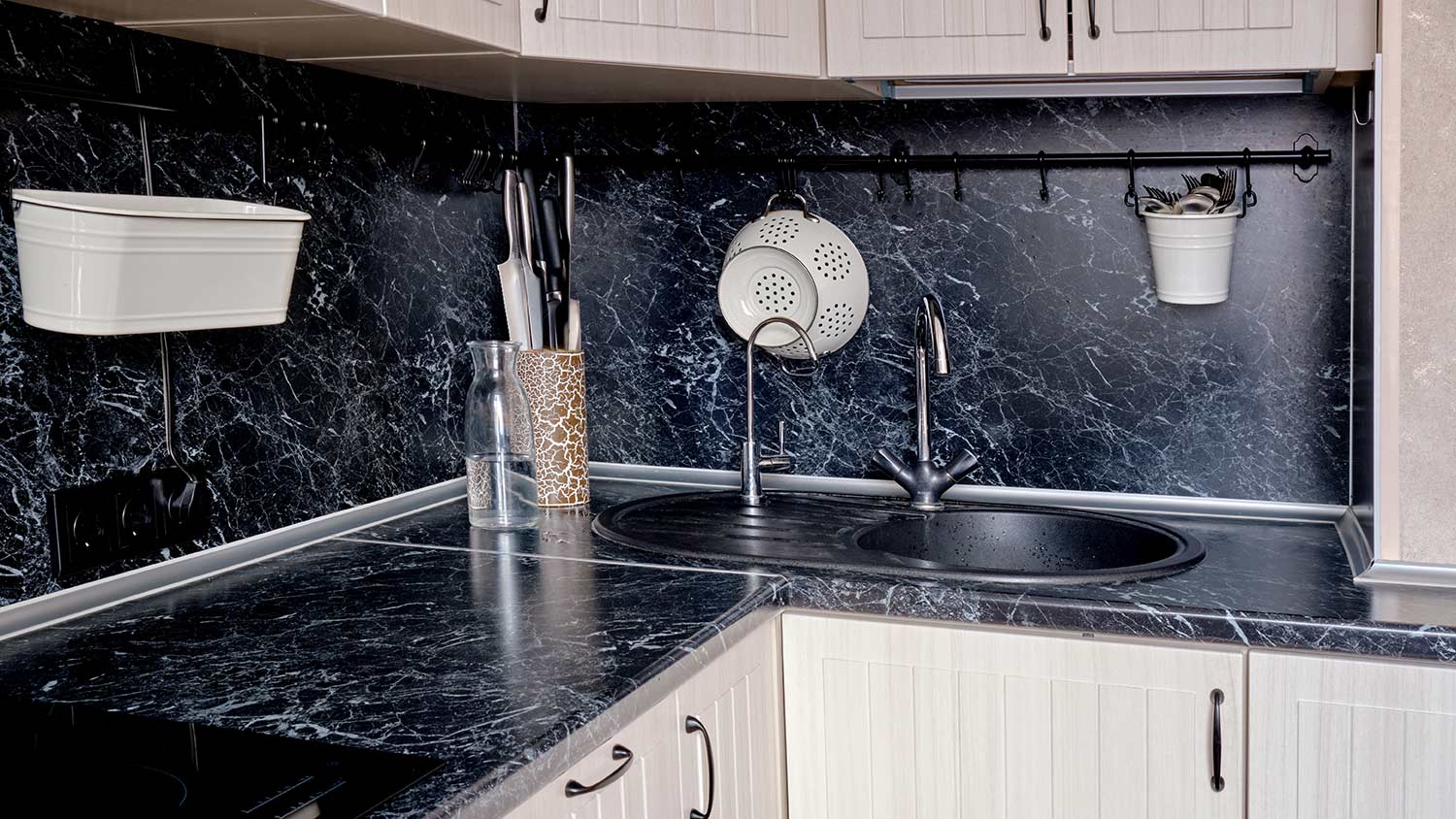 White cabinets with black marble pattern laminate countertops