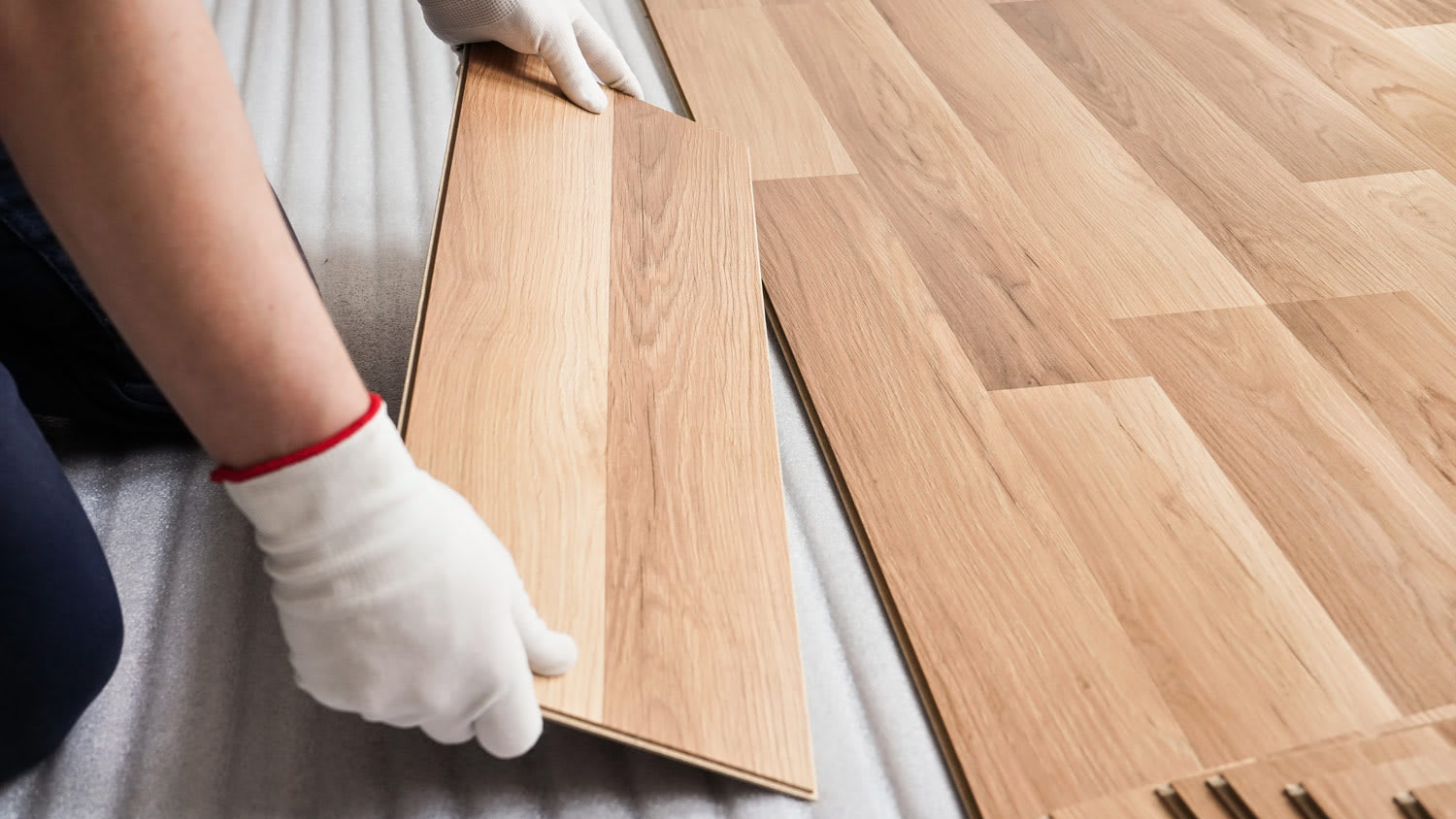 Detail of a professional installing laminate flooring