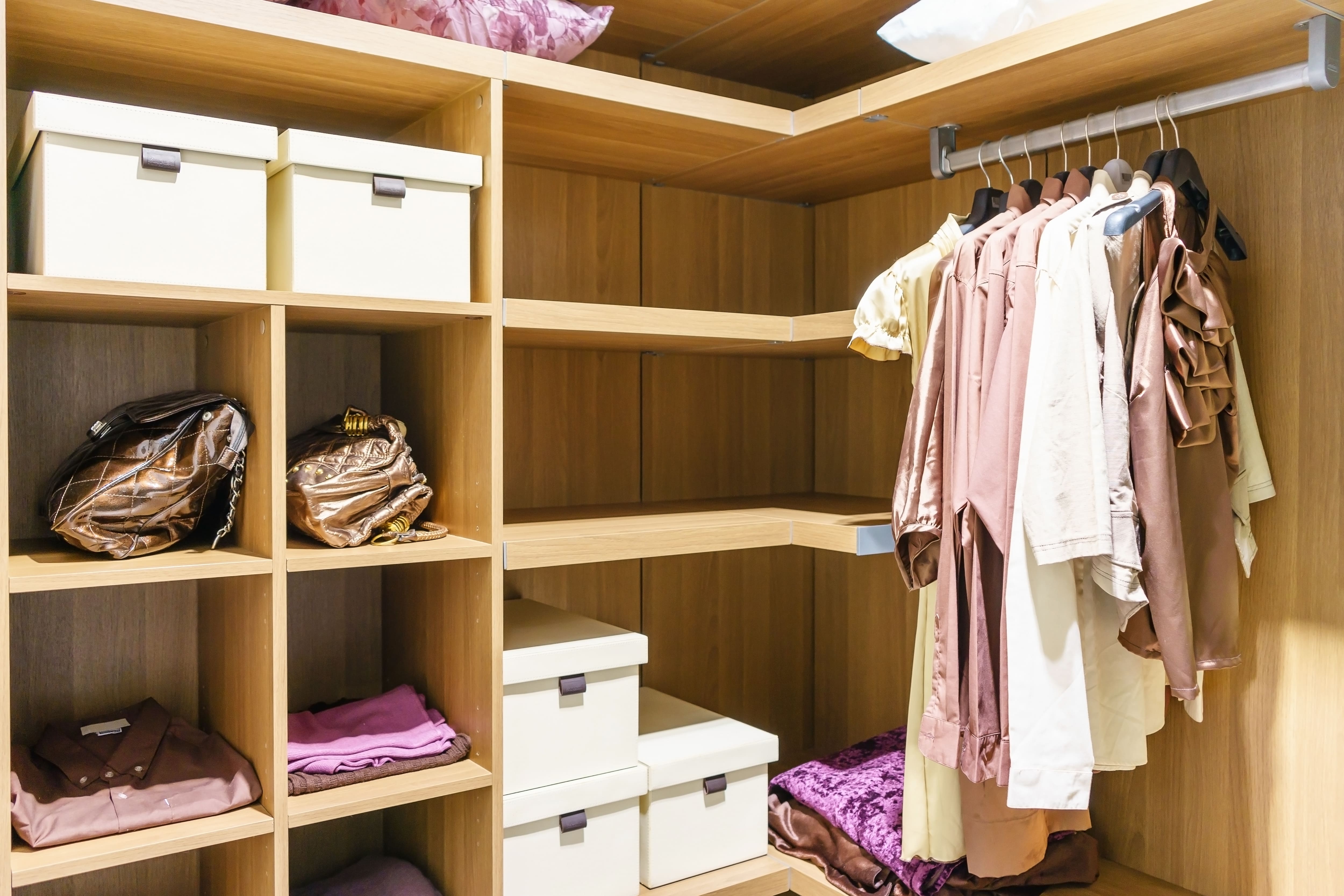 A small walk-in closet with yellow storage boxes