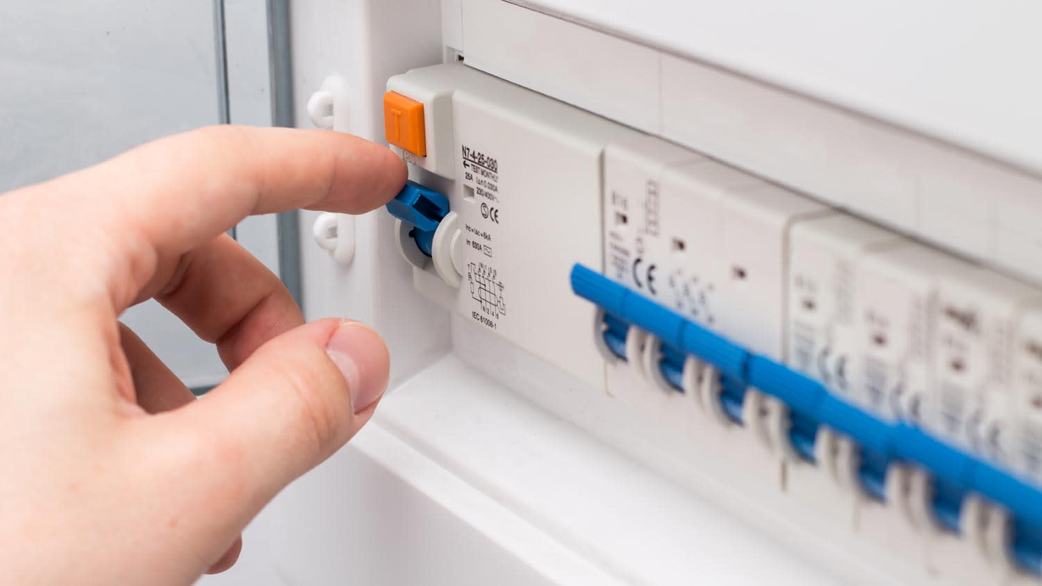 A hand turning off a circuit breaker