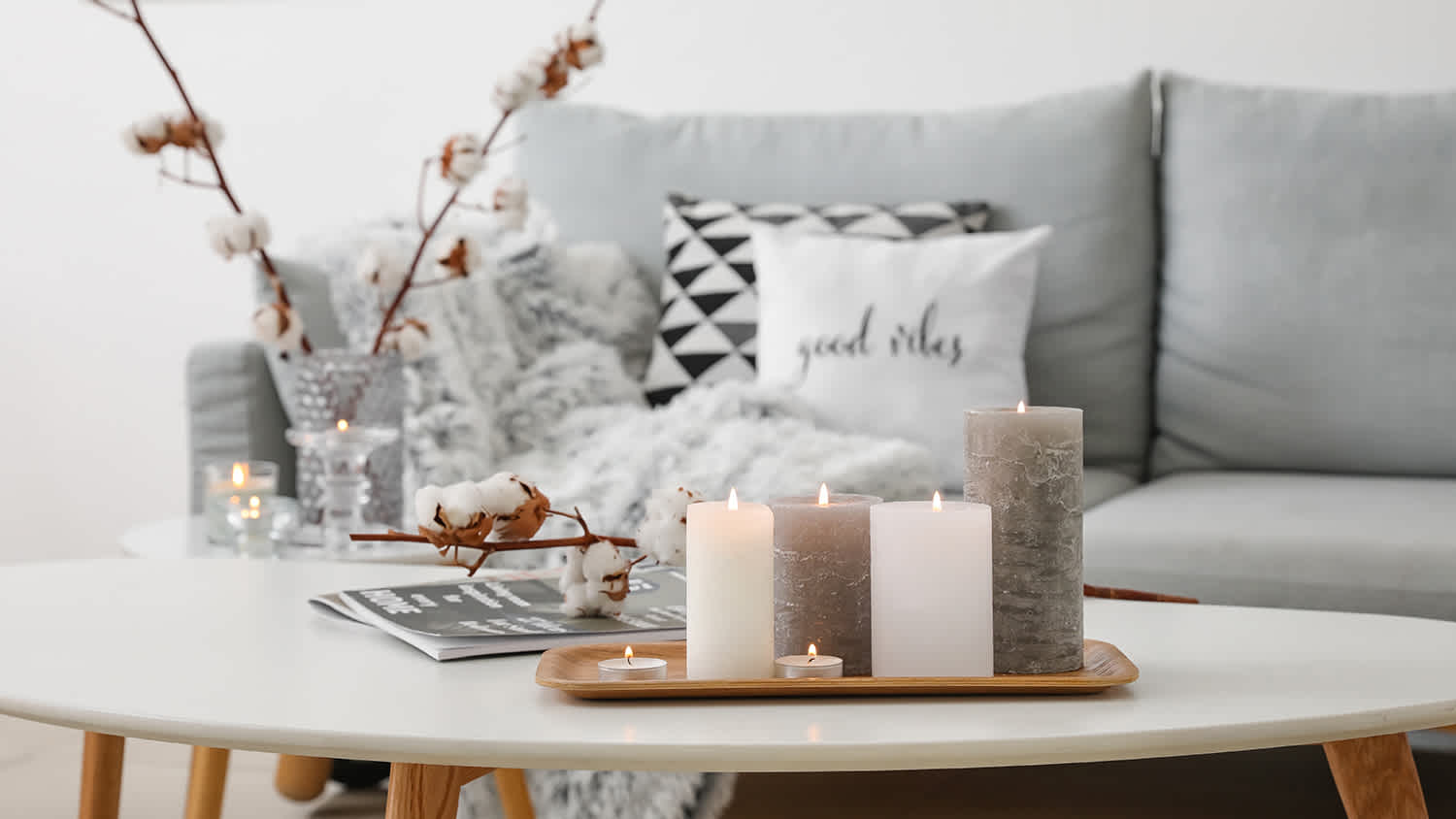 Burning candles on table in living room