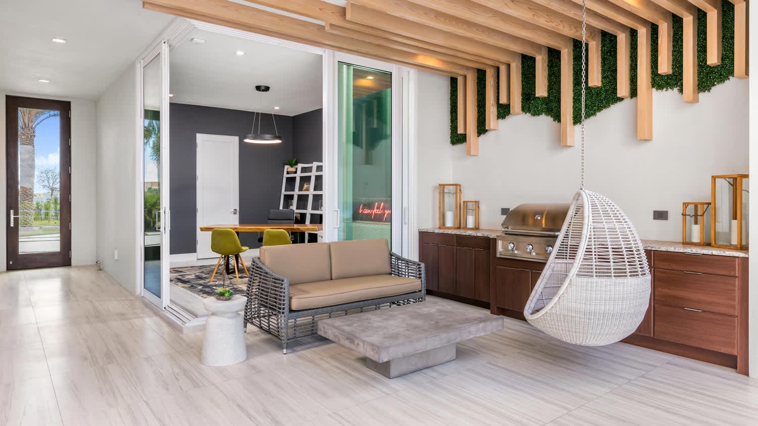 A modern covered patio with a hanging wicker chair