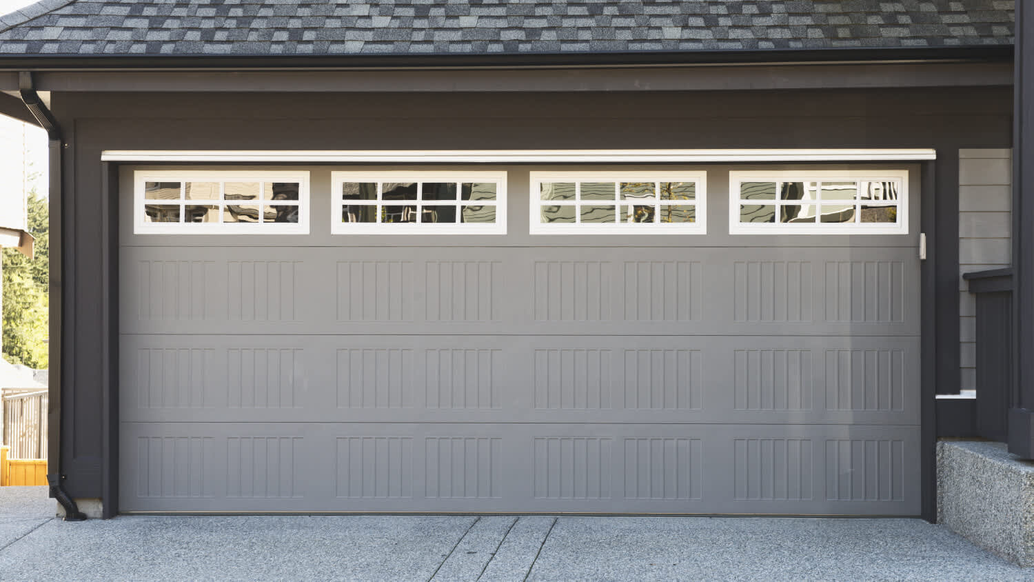 neutral gray garage door on dark house