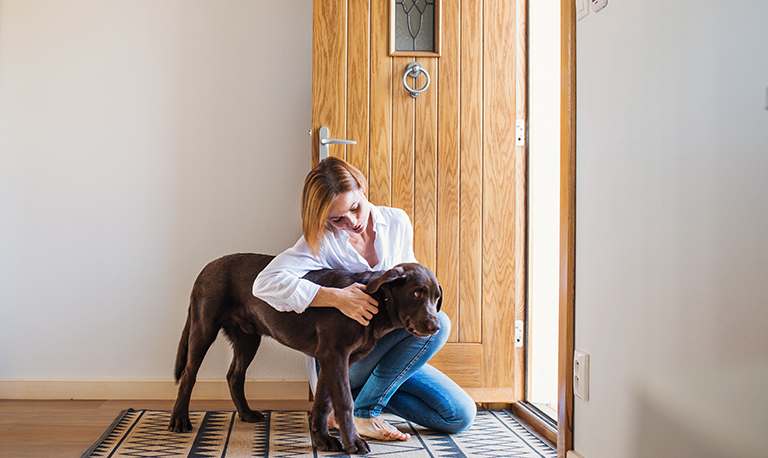 Woman pets dog by front door