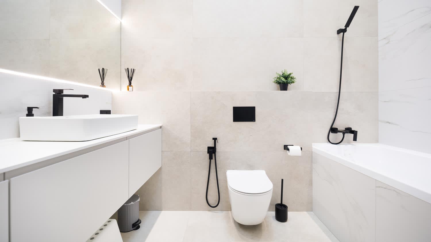 A minimal white bathroom with a toilet bowl and a bathtub