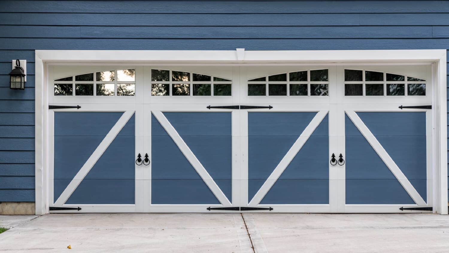 blue and white garage doors on blue house