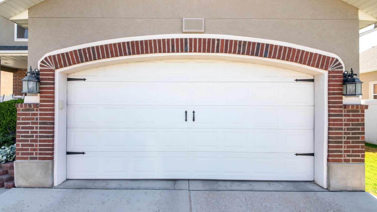 white carriage style garage door with brick trim