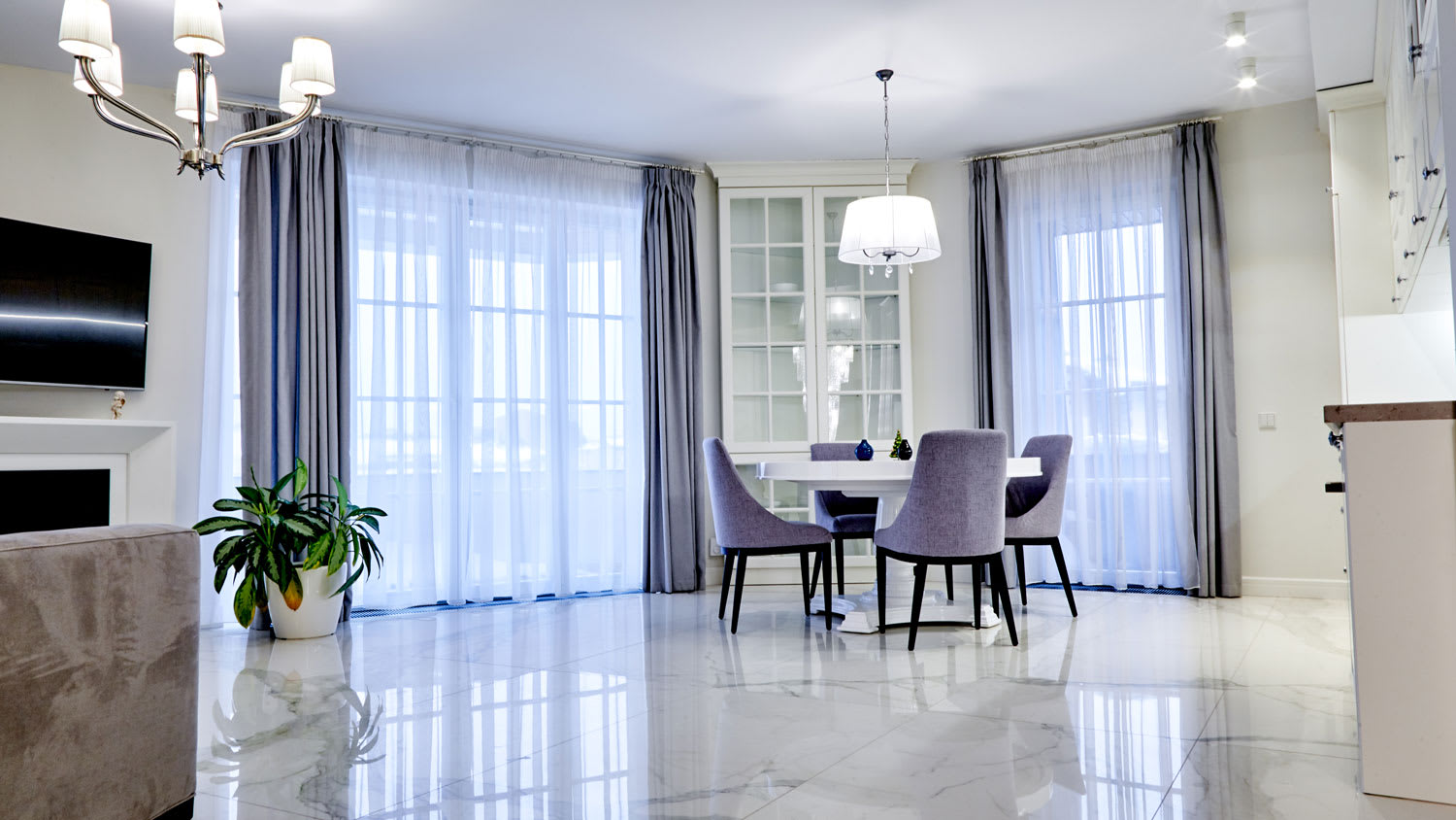 A house’s dining area with marble floors and a fireplace
