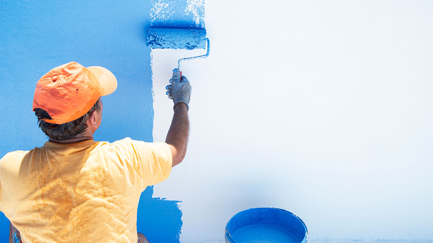 A man paints a swimming pool blue