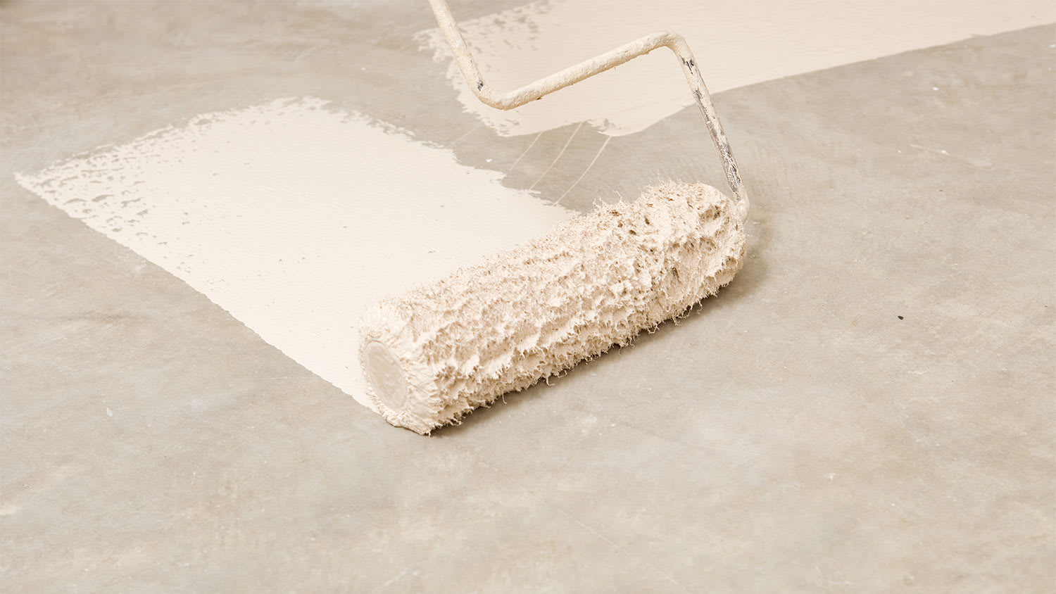 A closeup of a garage floor being painted