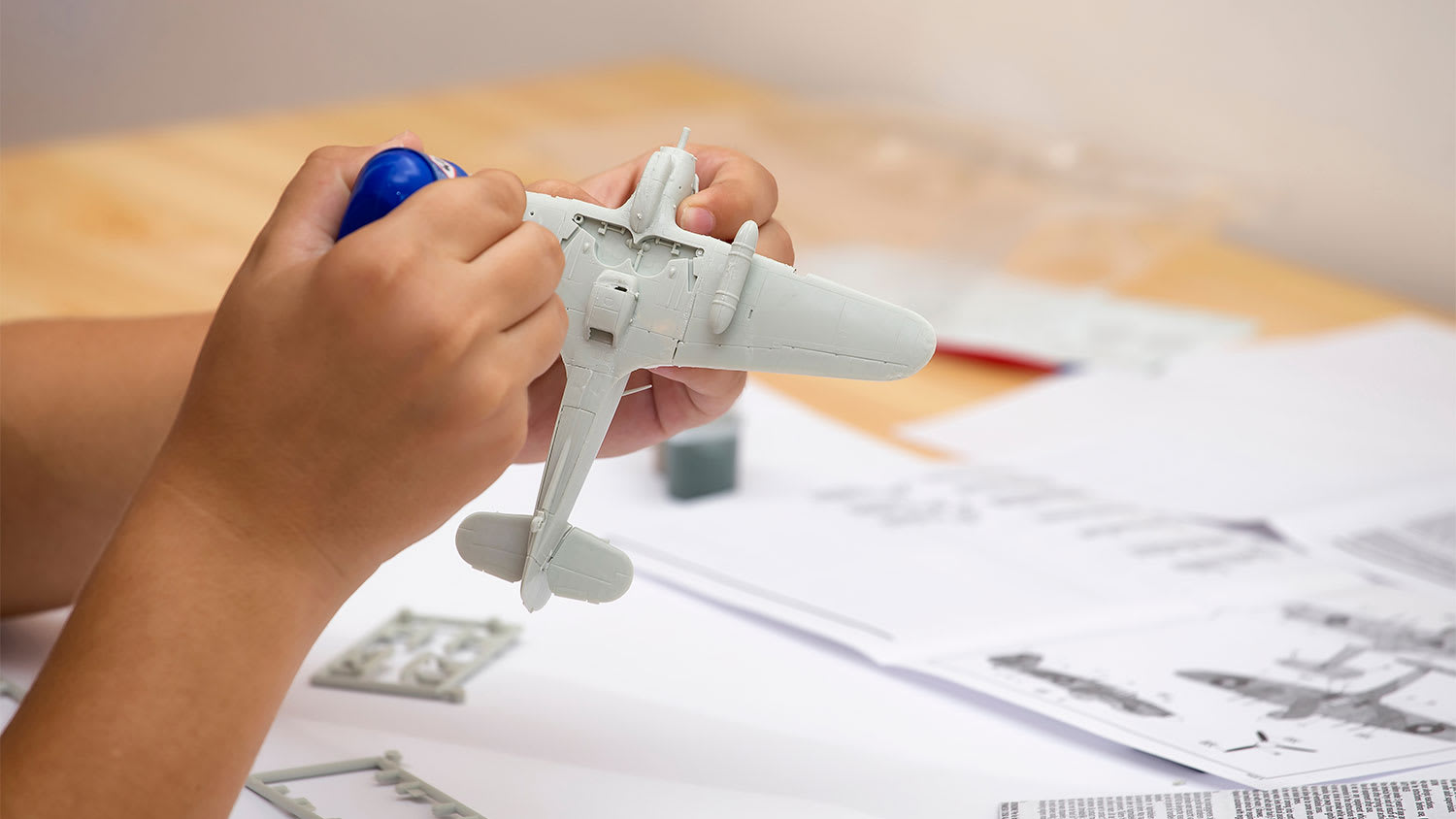 A view of a someone gluing a plastic model airplane