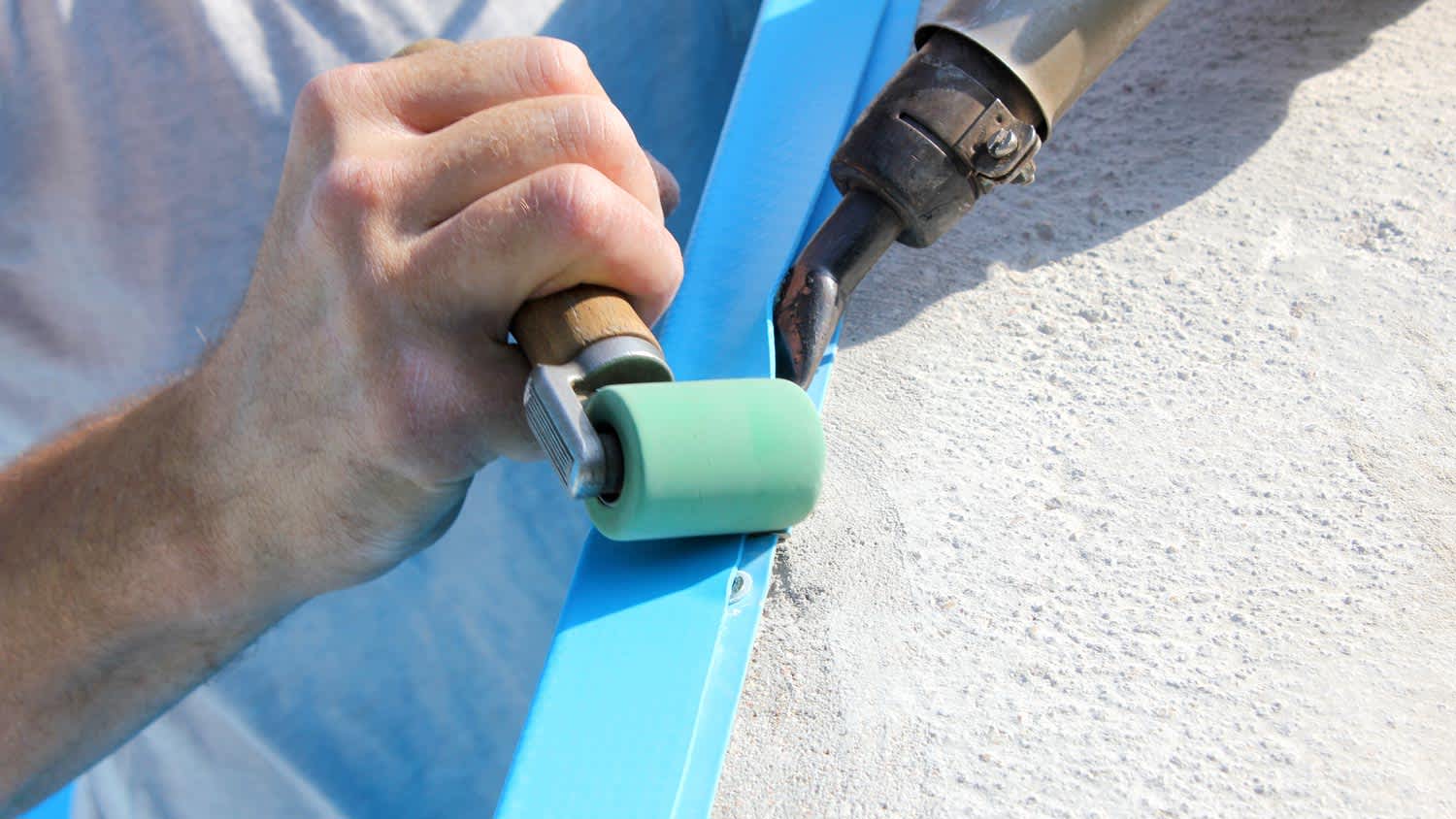 A worker patching the pool liner