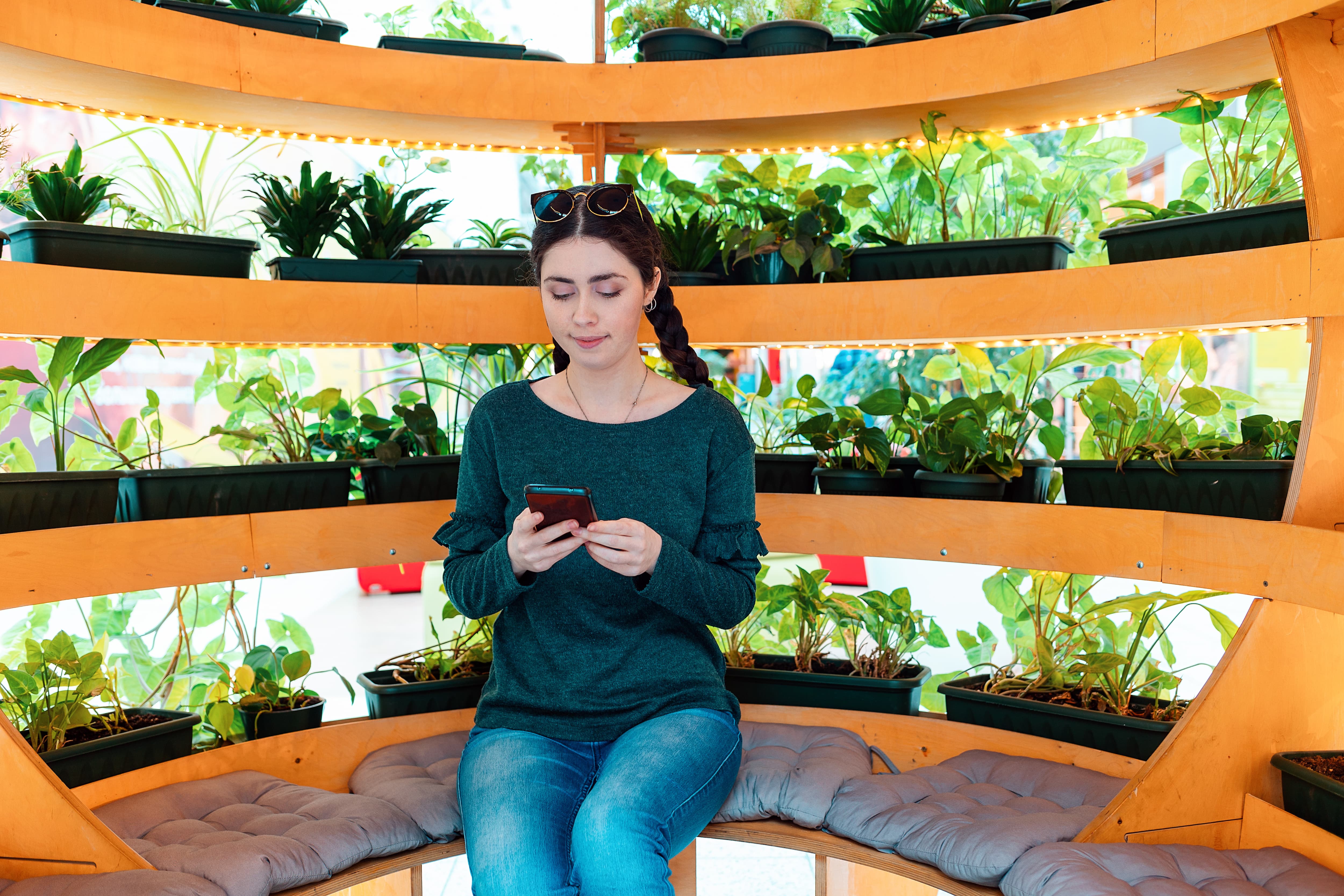 Girl sitting in gazebo used as a greenhouse