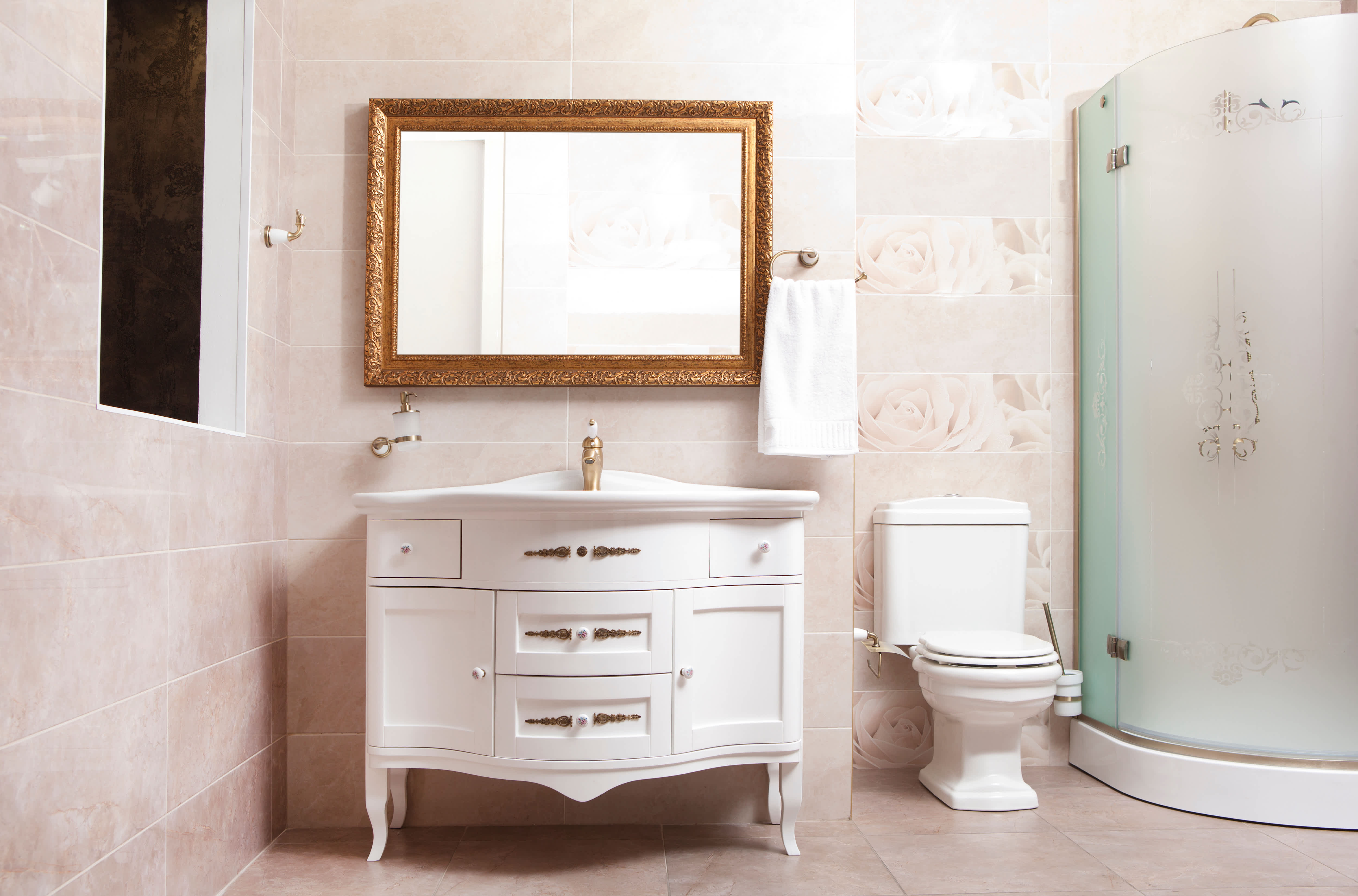 A bathroom with a frosted glass walk-in shower, vanity, and mirror