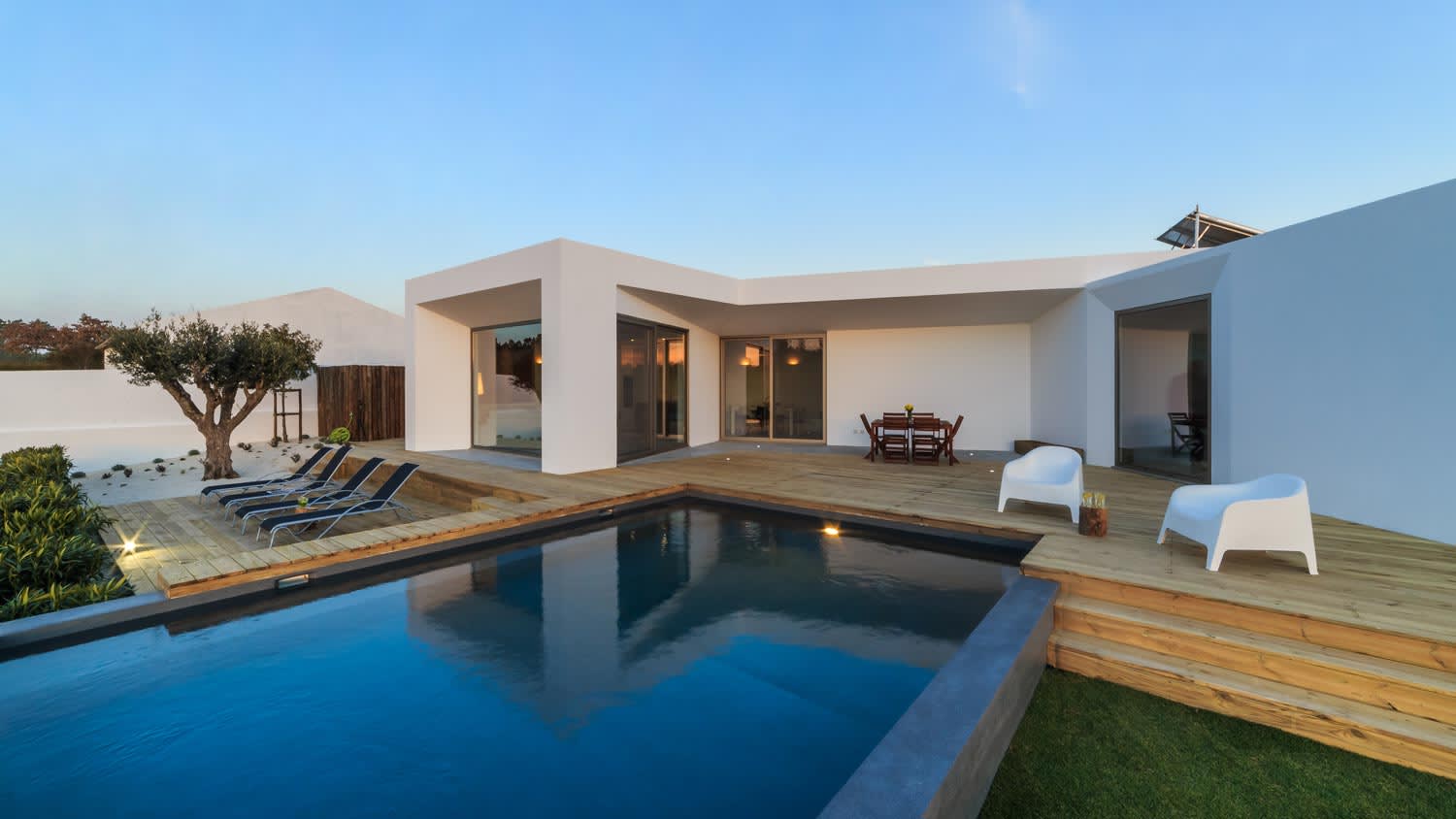 A modern house with a wooden deck and a pool
