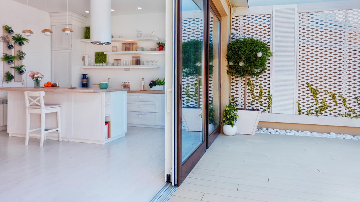 An open space kitchen with open sliding glass doors leading to a patio