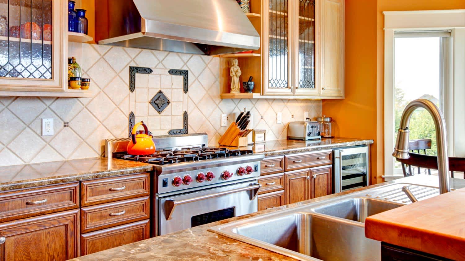 A sunny kitchen with an intricate tiled backsplash
