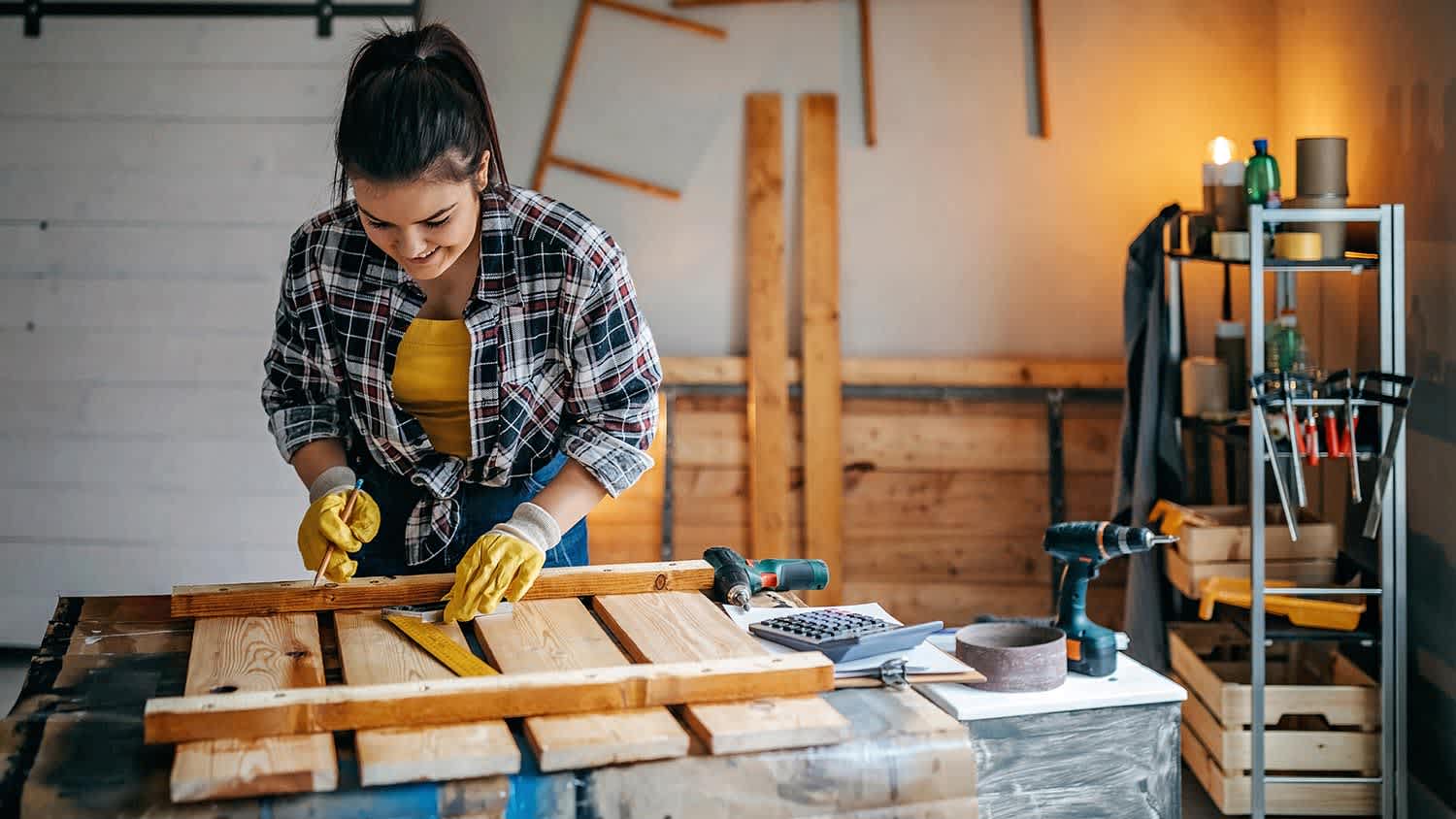 Woman works at workbench in garage