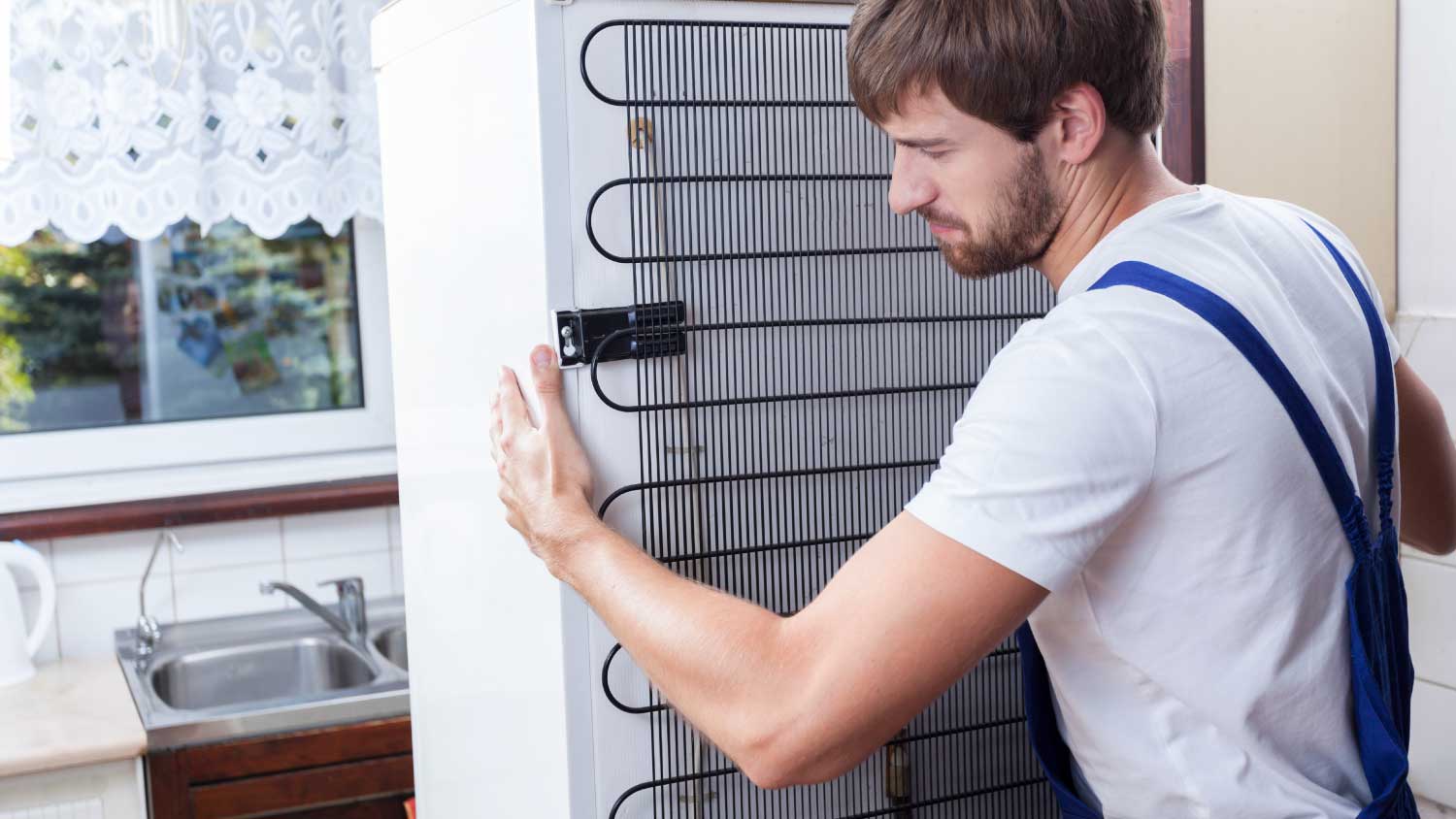 man moving old fridge