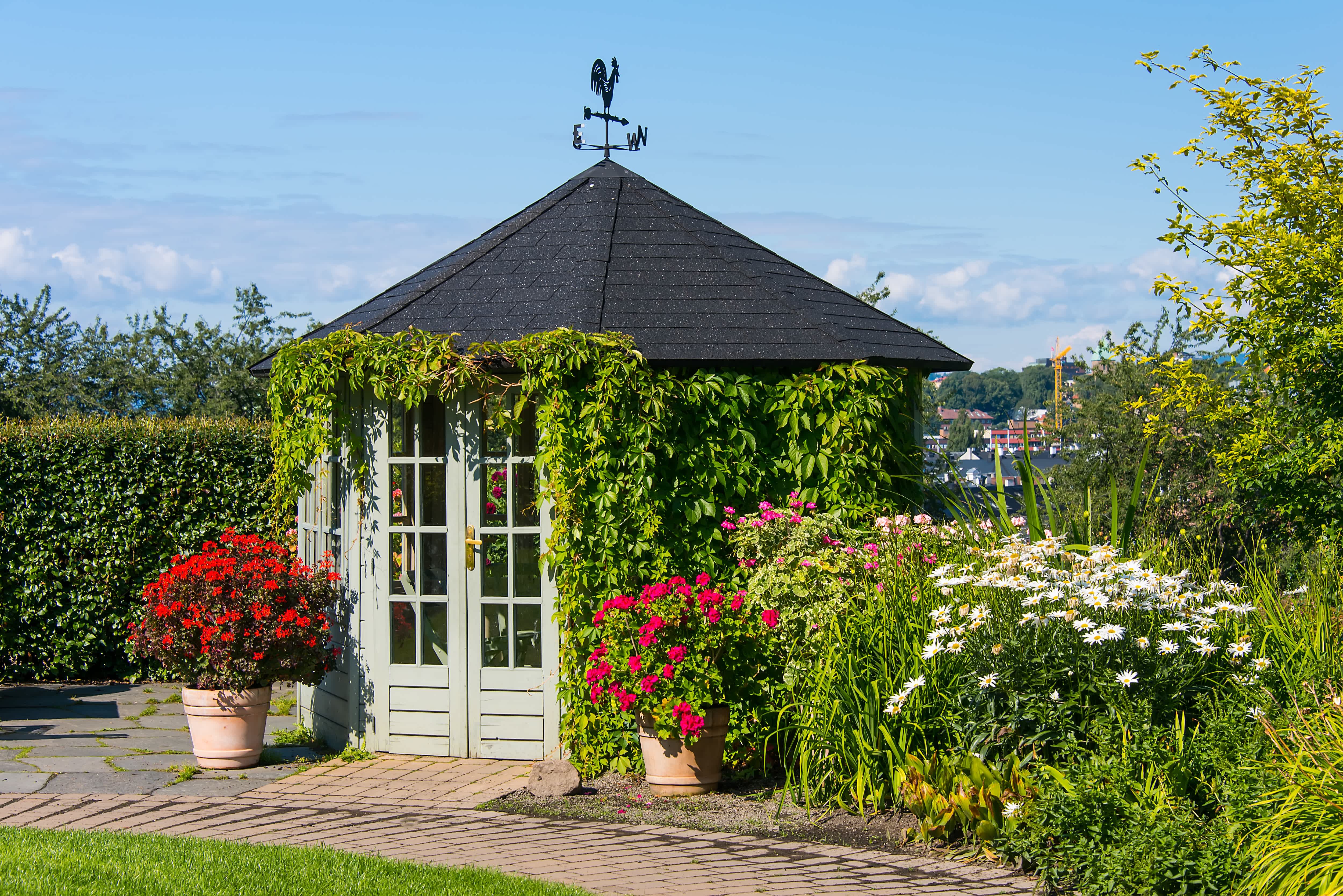 Gazebo in garden with enclosed sides and doors