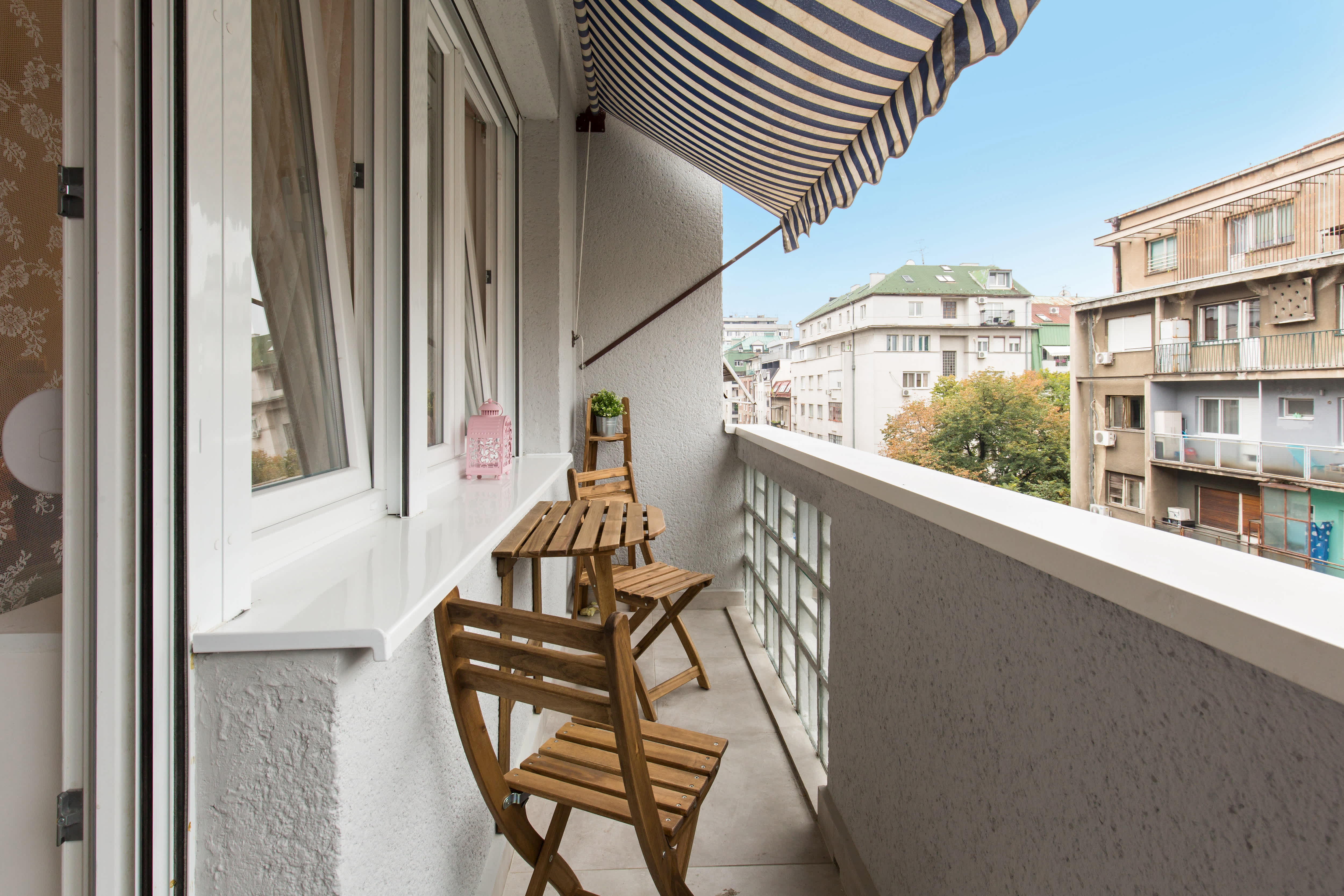 Striped retractable awning covering small balcony