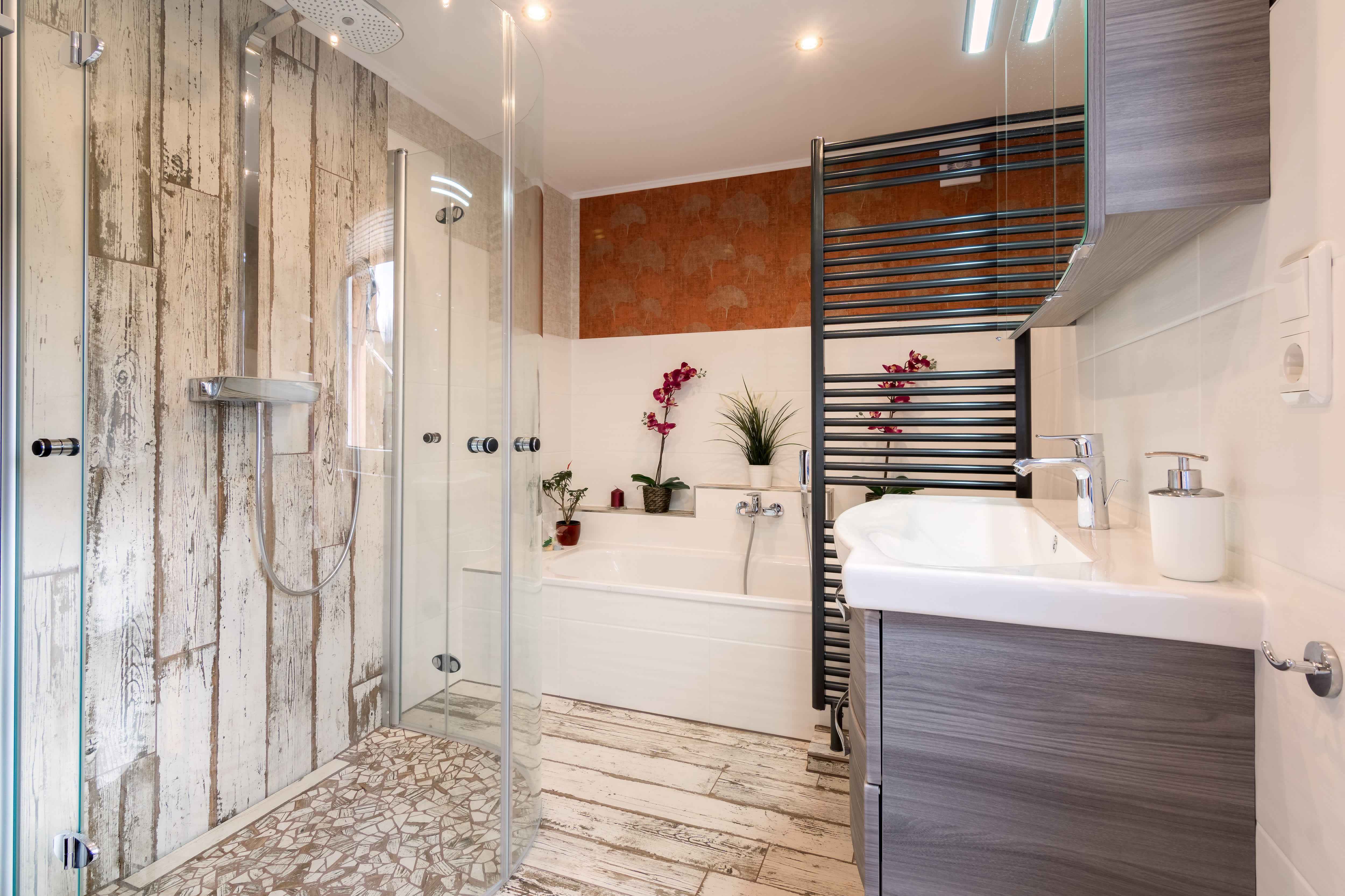A brown and white bathroom with a rounded glass walk-in shower