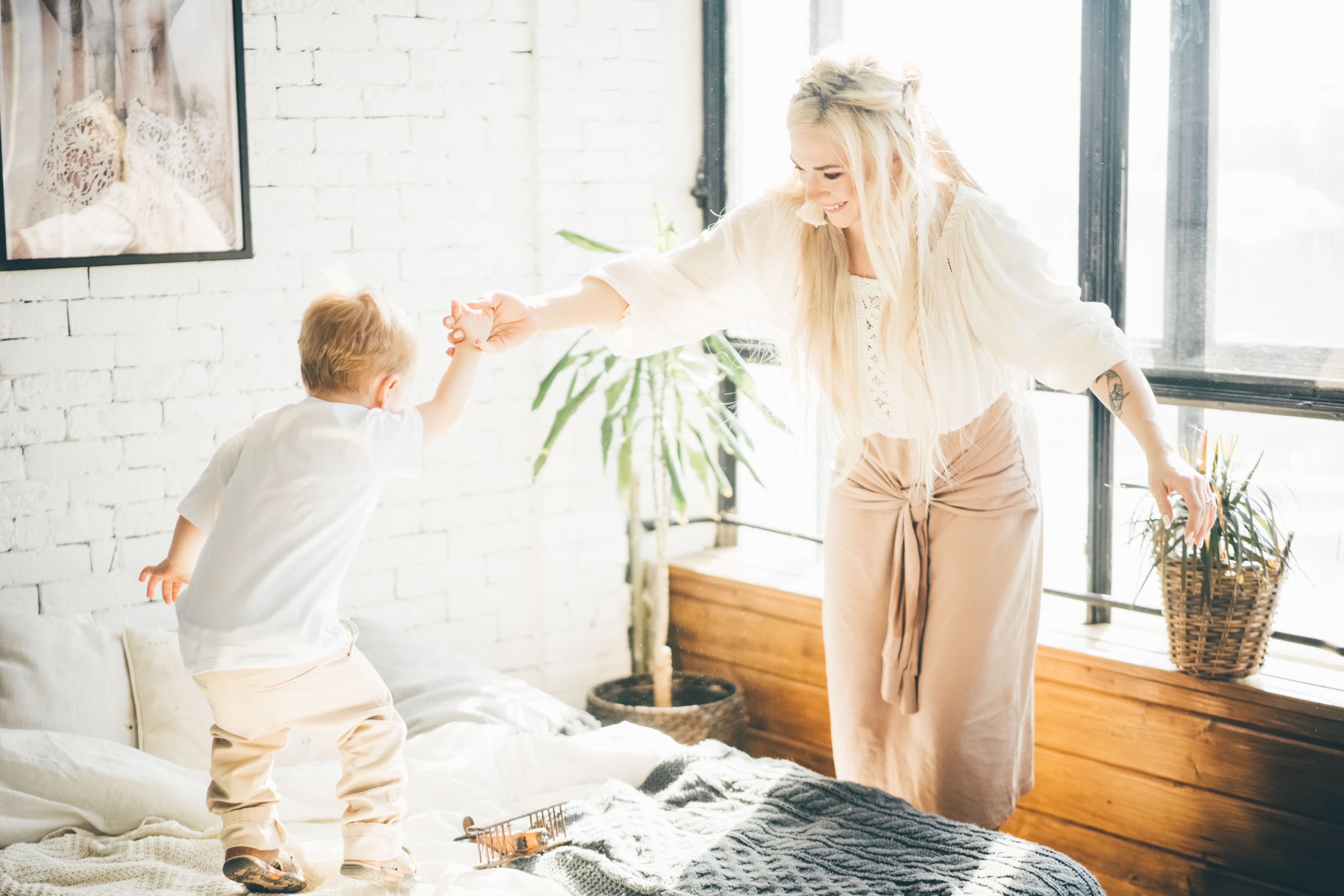 Mother and son playing in bohemian-inspired bedroom