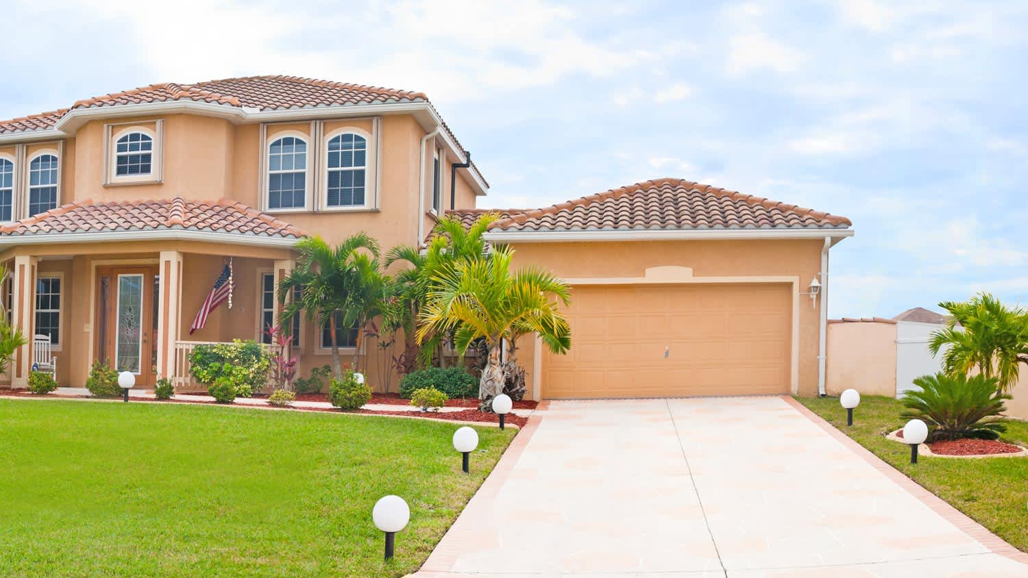 A steep driveway leading to a house with palm trees