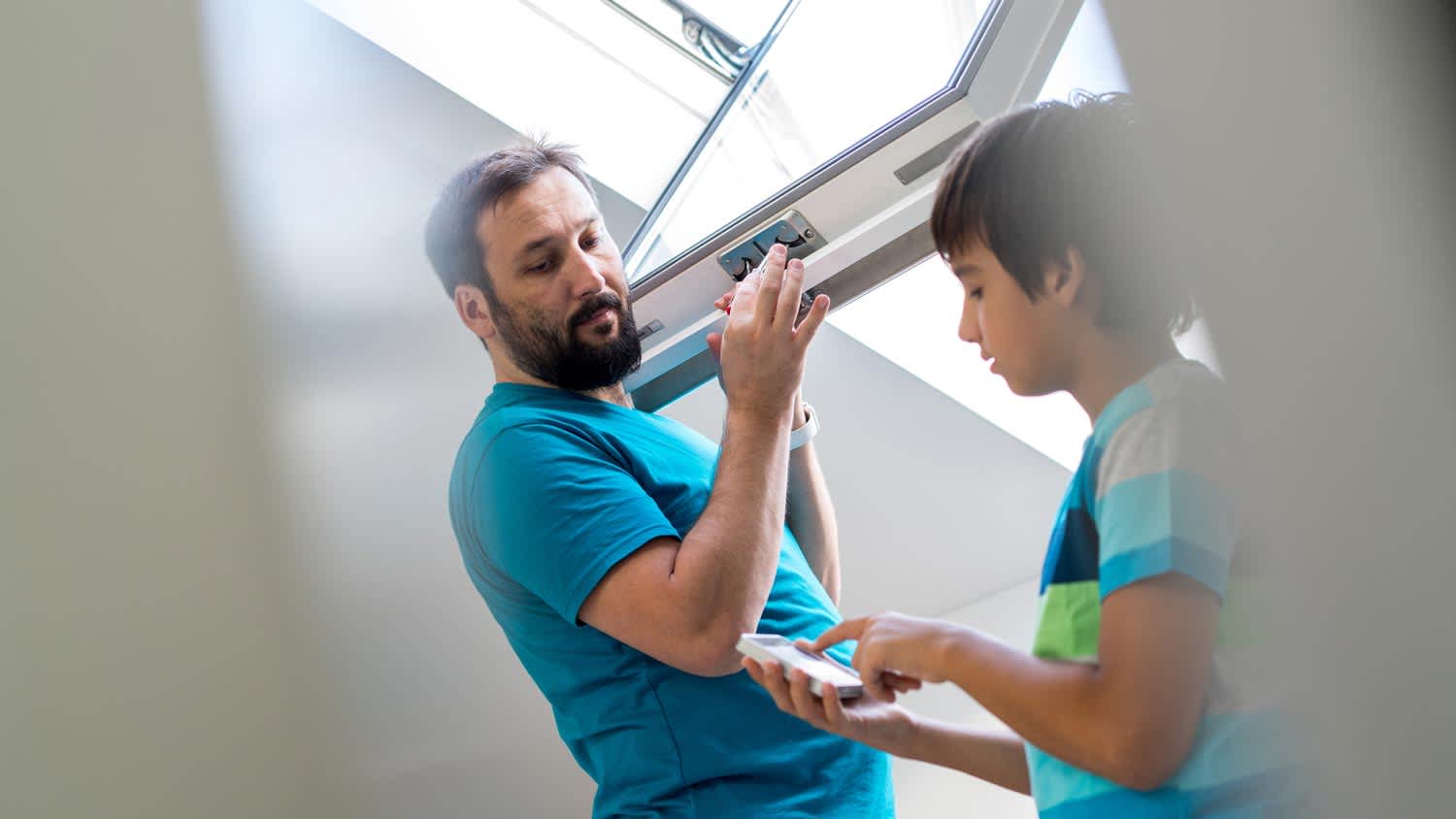 A father with his son checking a roof window