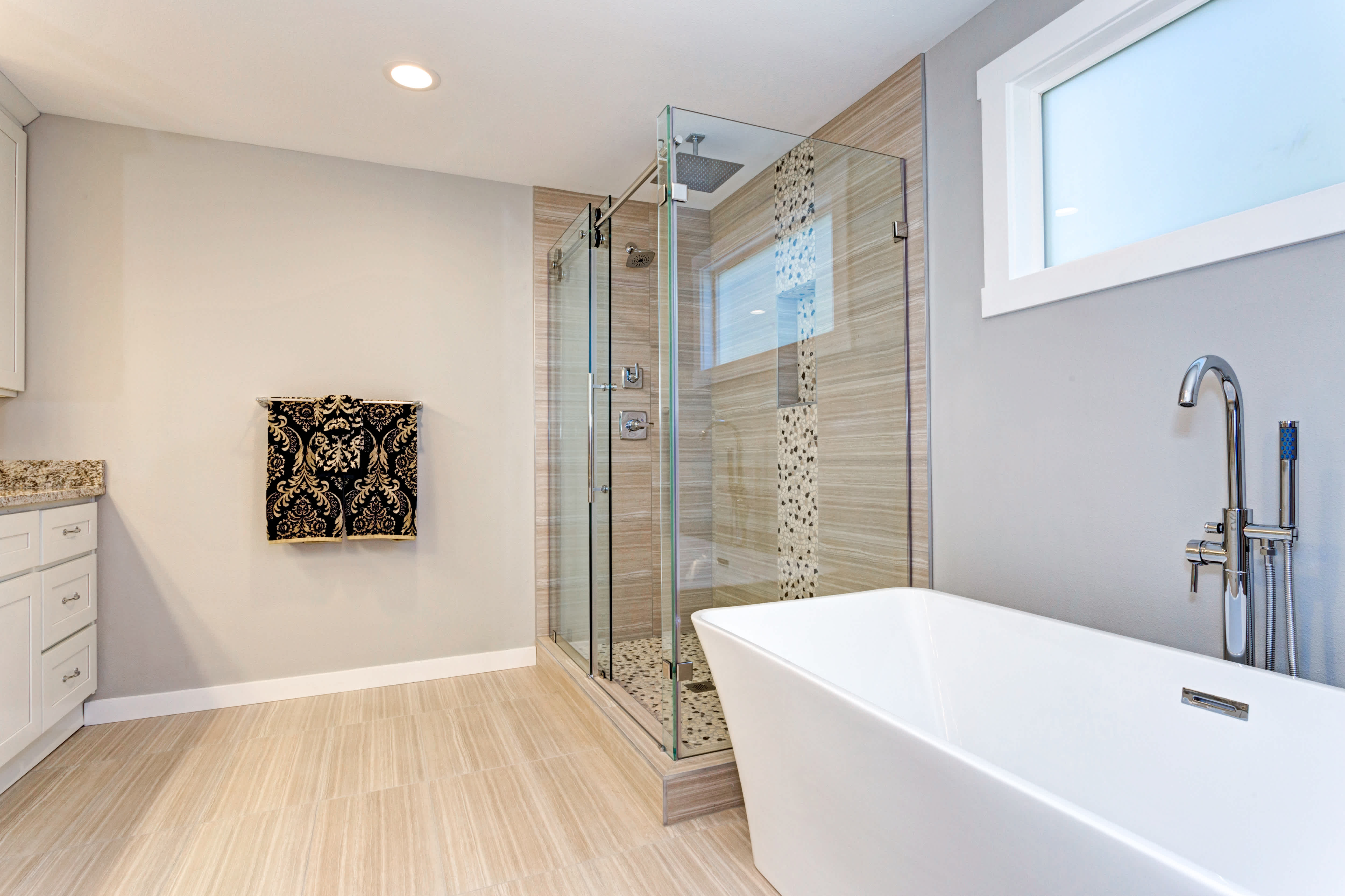 Walk-in shower with one sliding glass door and gold accents