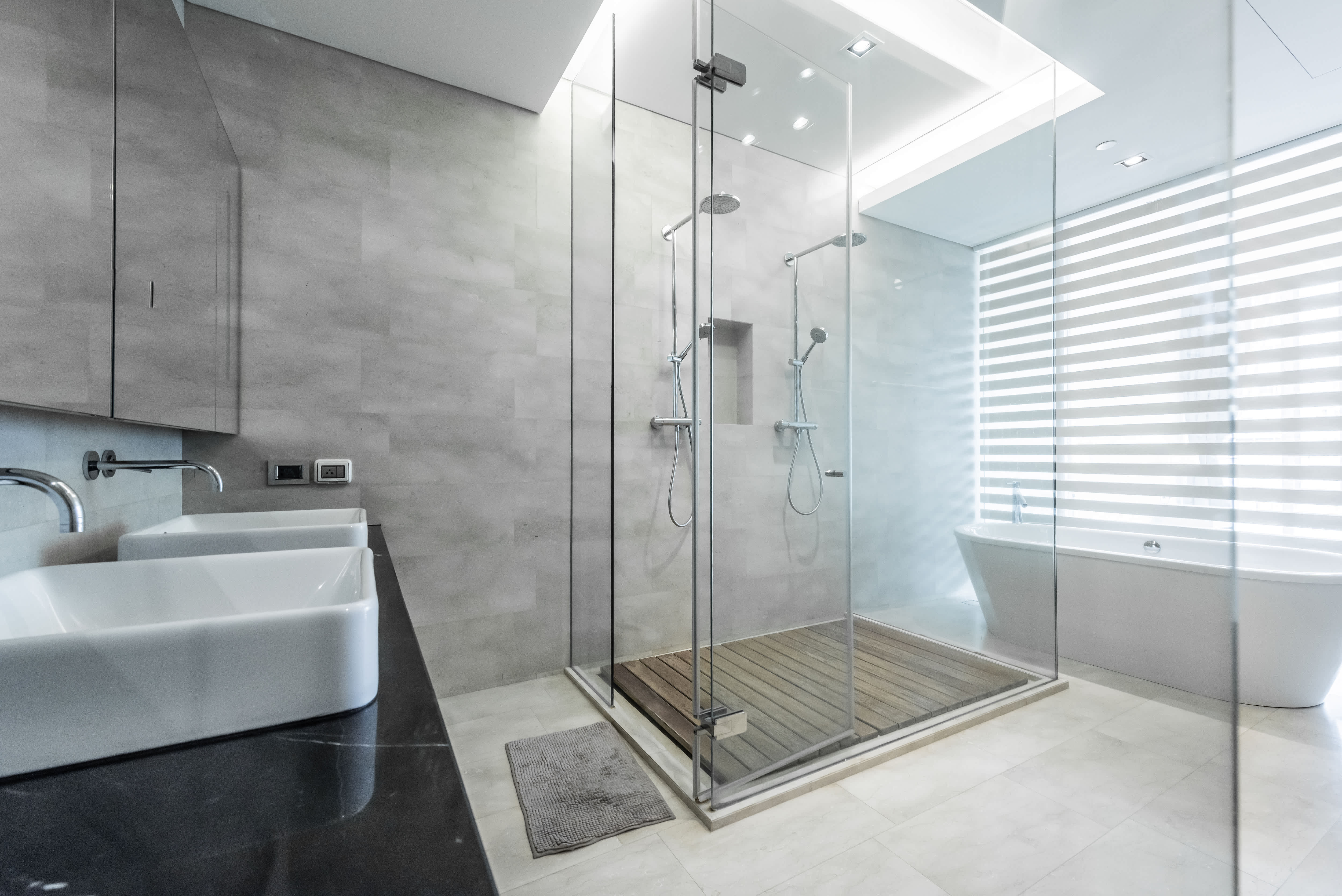 Large marble bathroom walk-in shower, bathtub, and two sinks