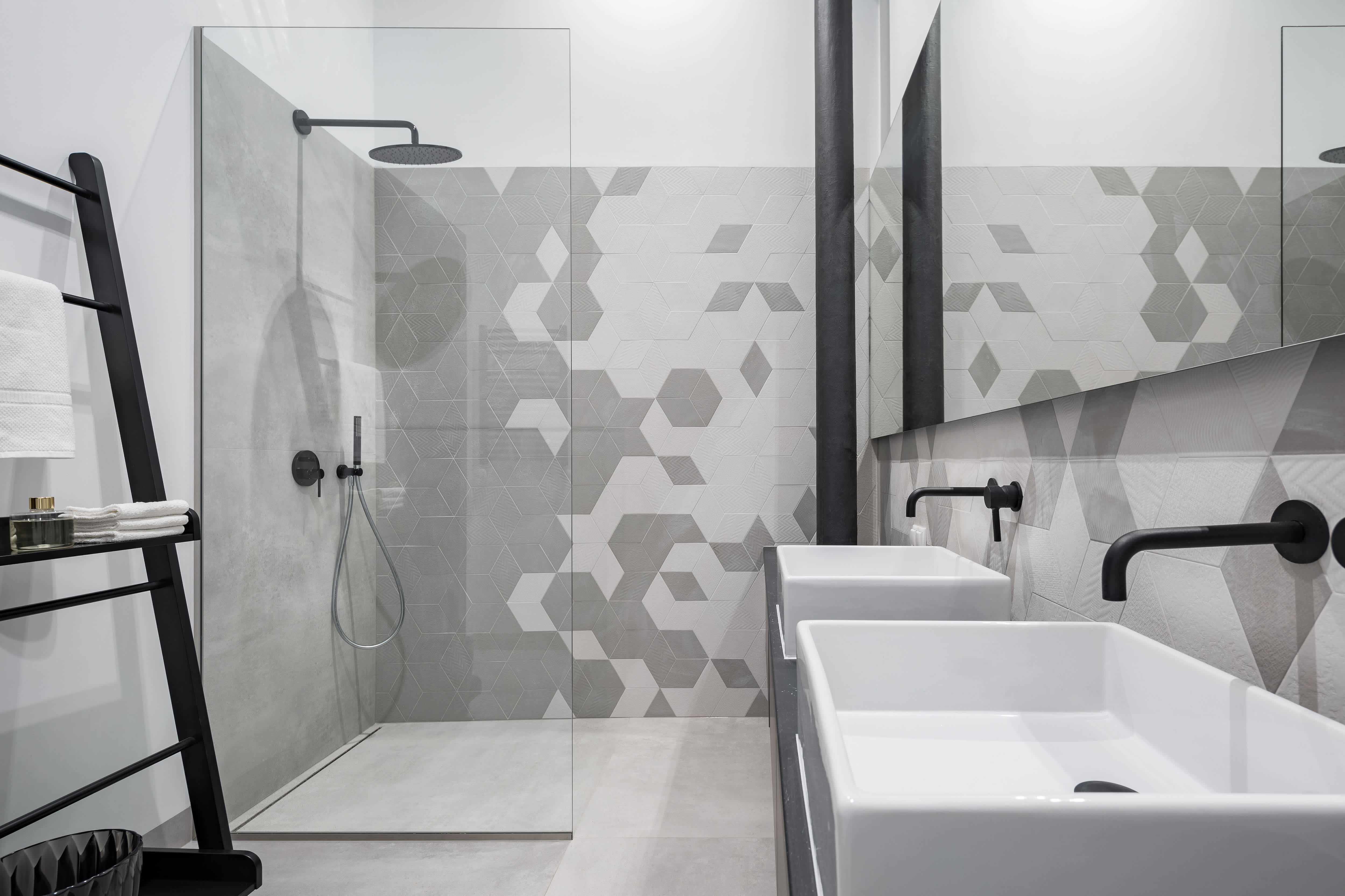 A modern bathroom with a walk-in shower and geometric tile pattern