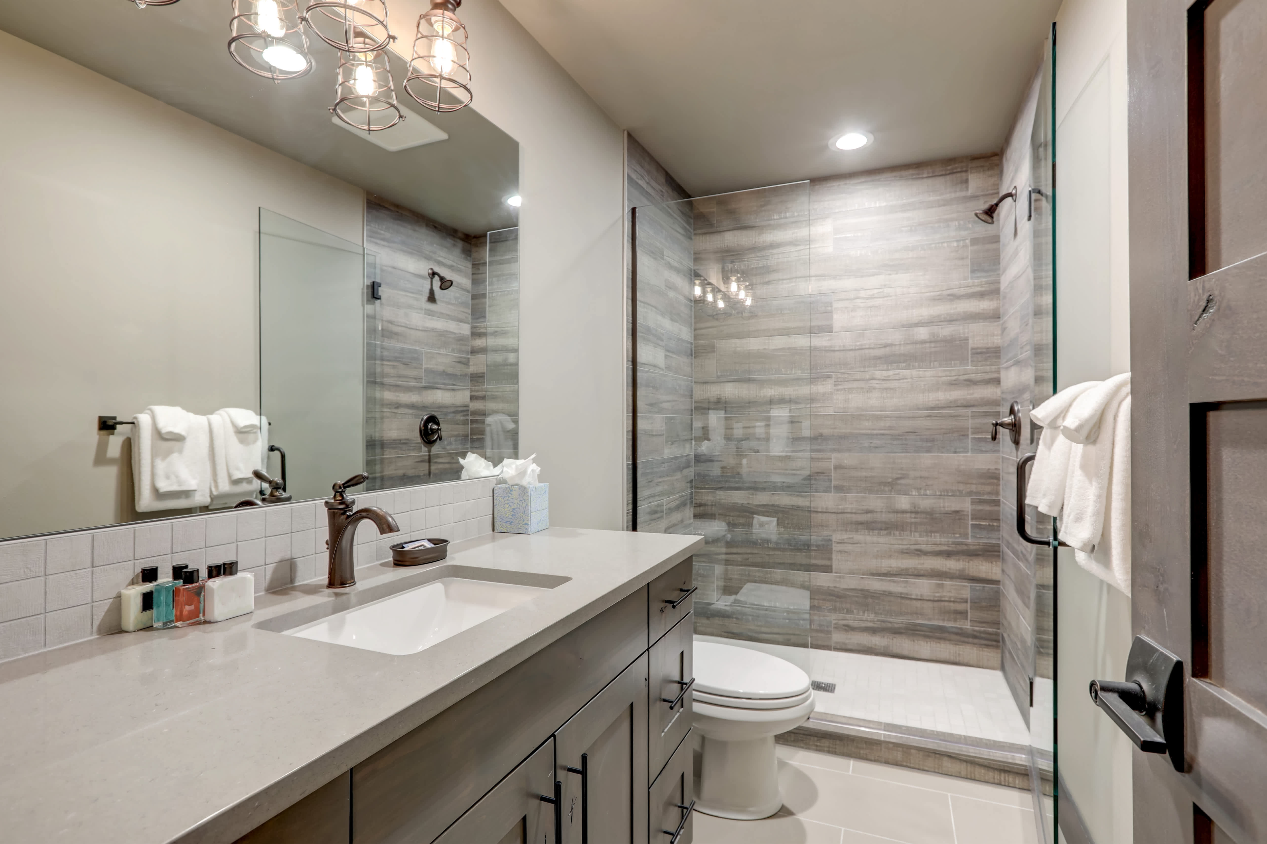 A small bathroom with a slate gray walk-in shower tile