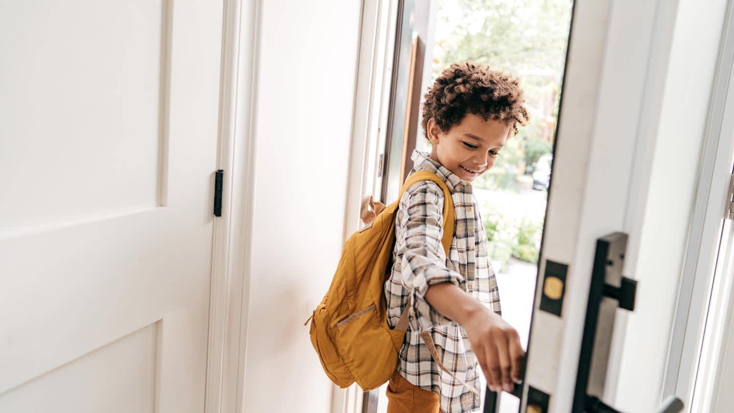 A young boy closing the door behind him