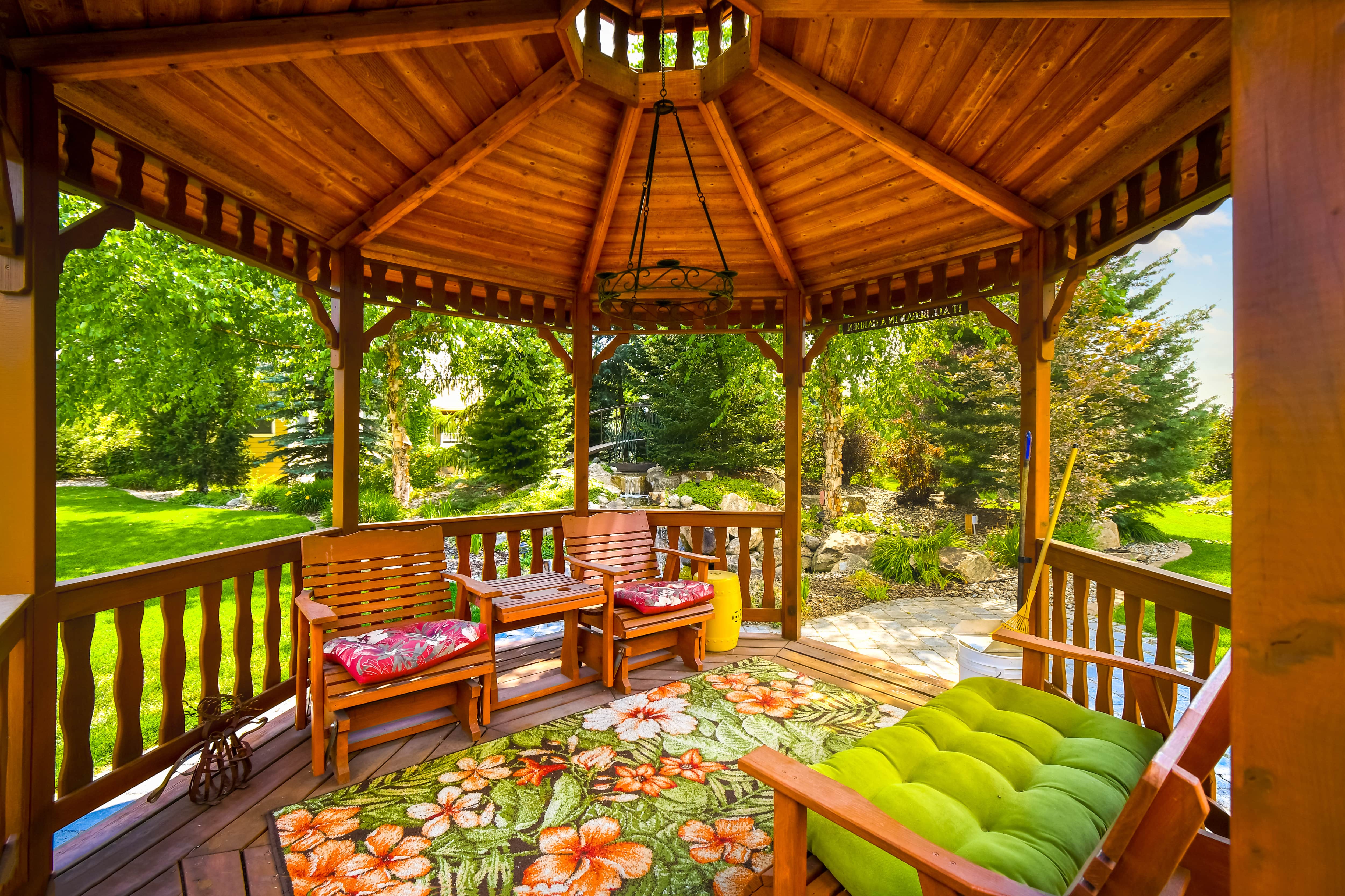 Metal frame chandelier hung in wooden gazebo