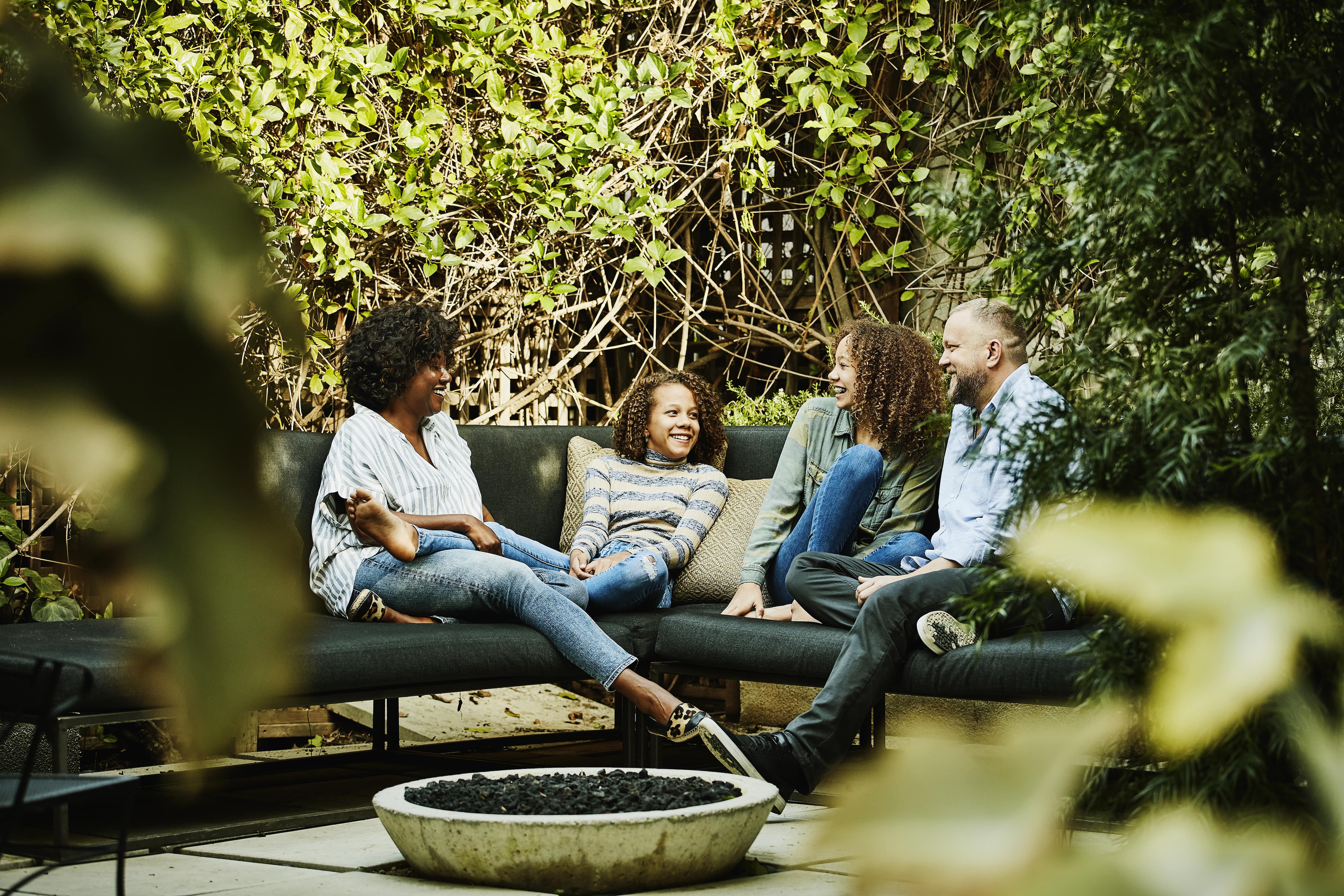 Family sitting around a fire pit on a outdoor sectional